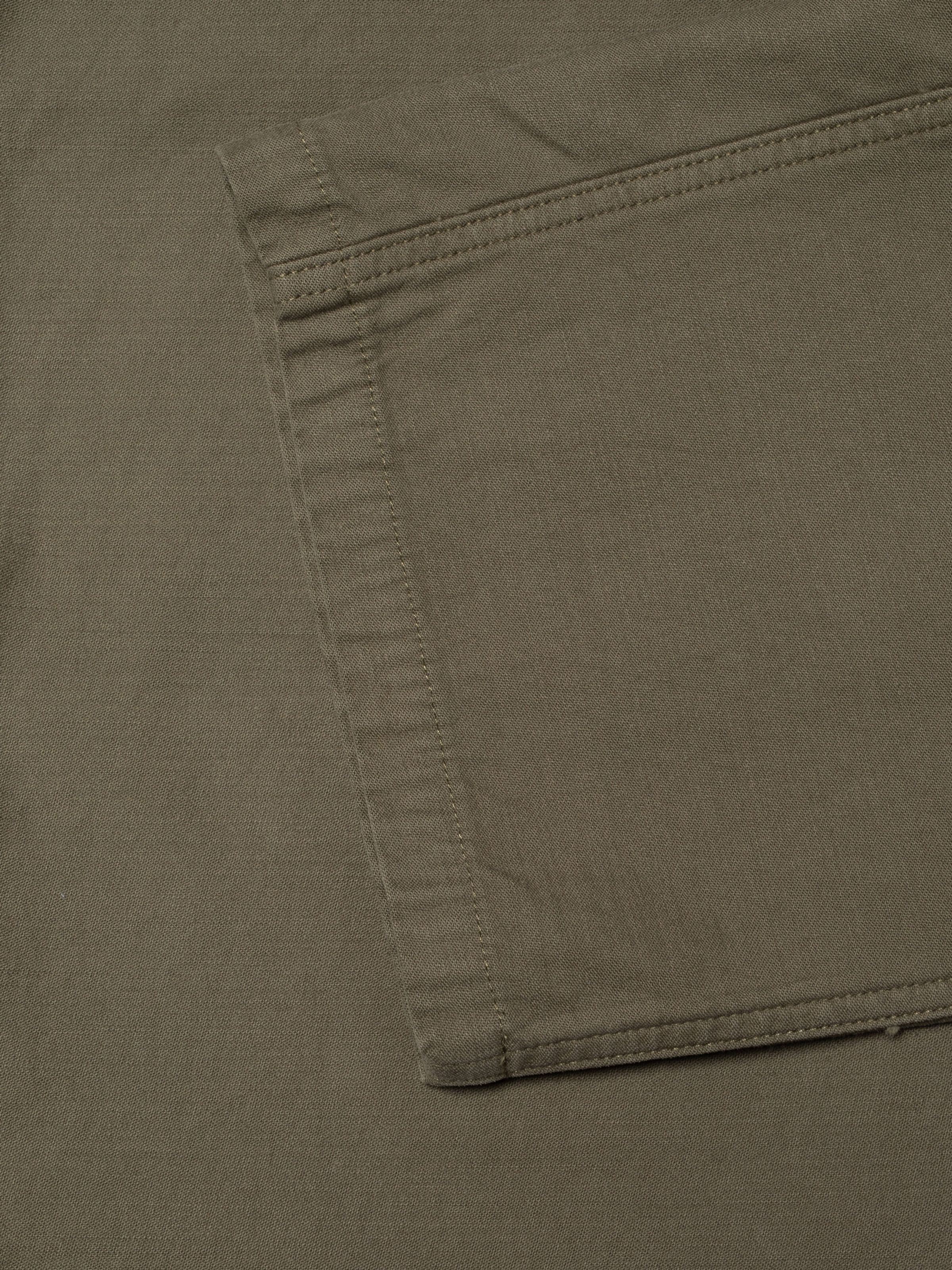 Nudie Jeans Tuff Tony Pants BS Olive Green, close-up of the pocket detail and organic cotton sateen fabric texture.