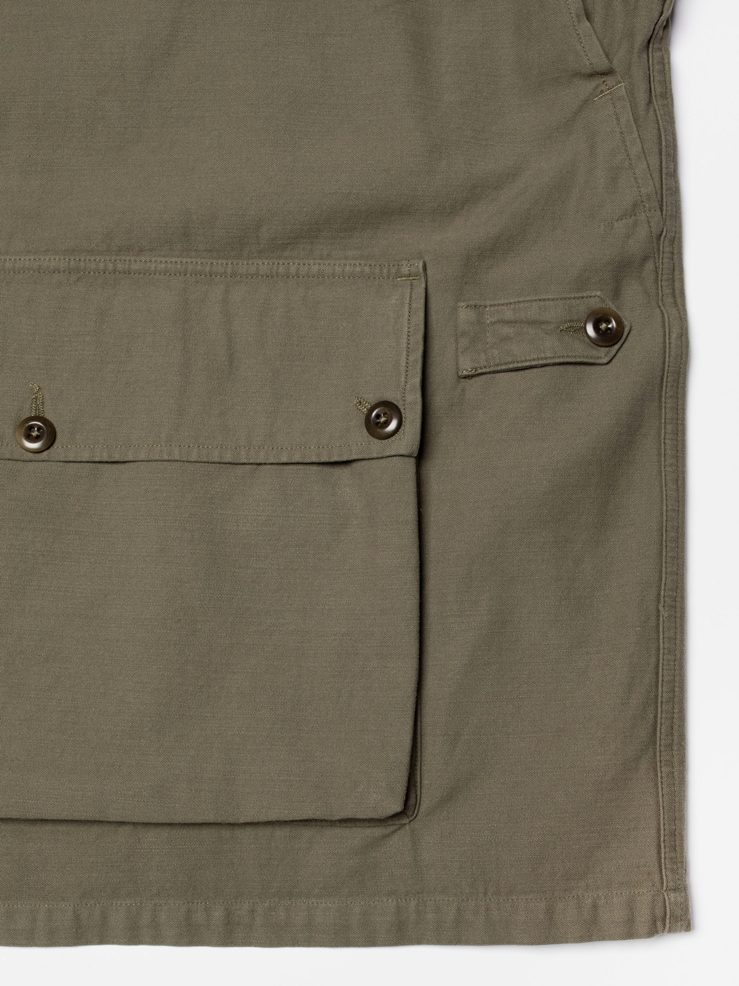 Nudie Jeans Bror Field Jacket in Olive Green, close-up of the front pocket and organic cotton sateen texture.