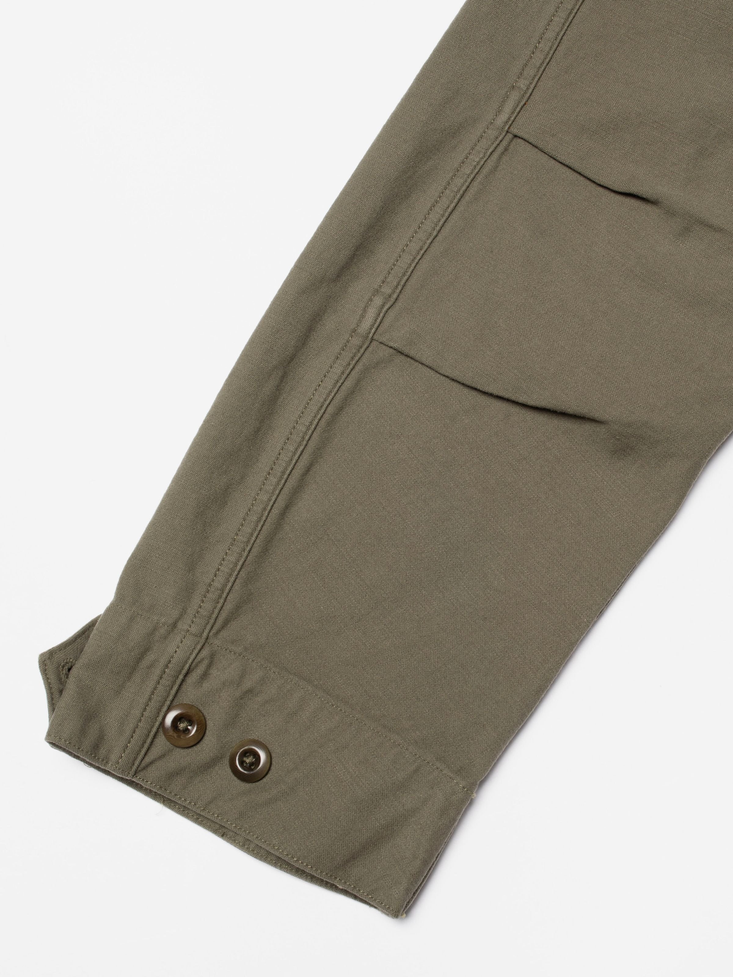 Nudie Jeans Bror Field Jacket in Olive Green, showing a close-up of the sleeve cuff and organic cotton sateen fabric texture.