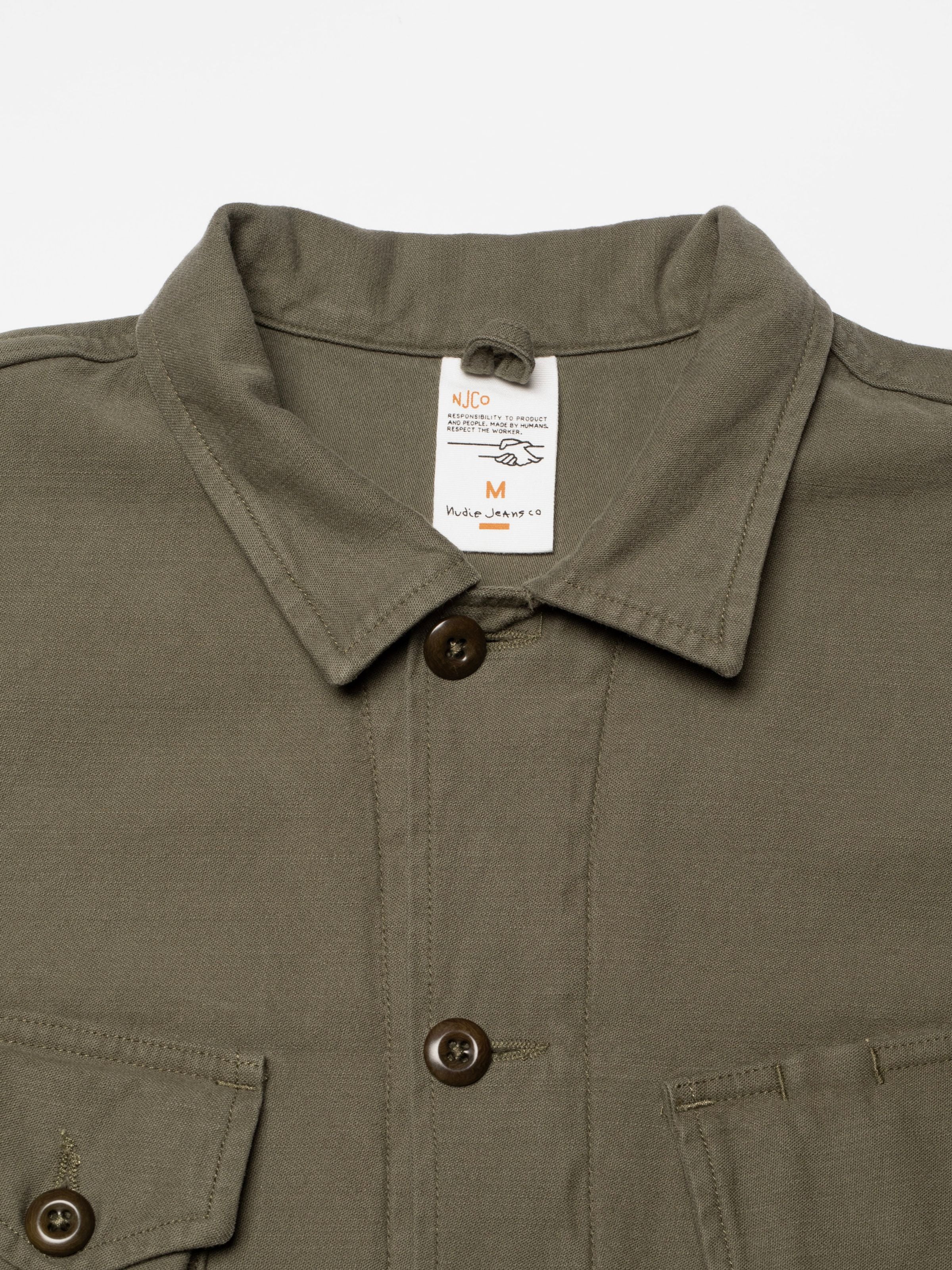 Nudie Jeans Bror Field Jacket in Olive Green, close-up of the collar, corozo buttons, and organic cotton sateen texture.