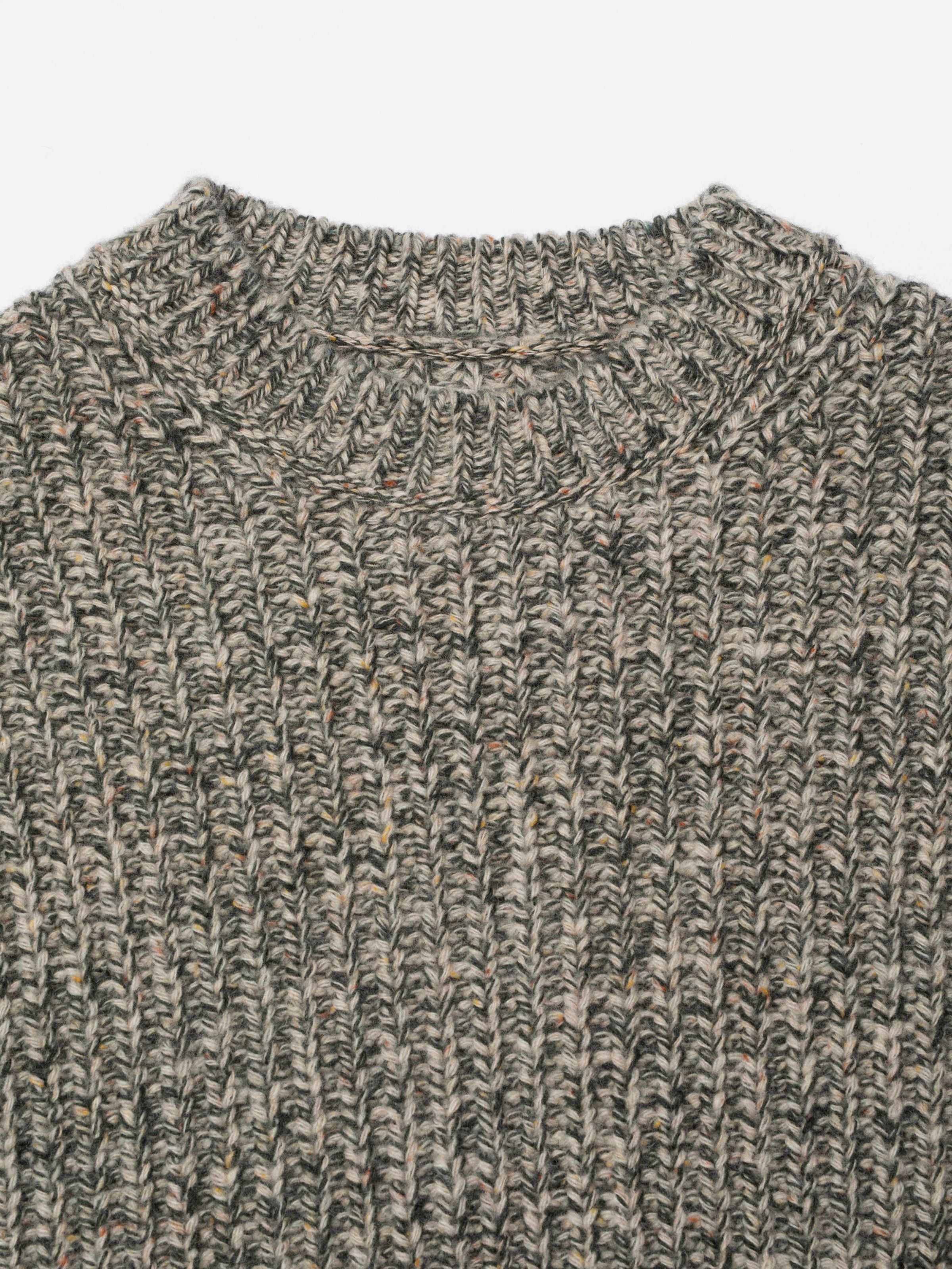 Nudie Jeans Gittan Sweater Chunky Knit in Green Melange, close-up showing the ribbed crew neck and organic wool knit texture.
