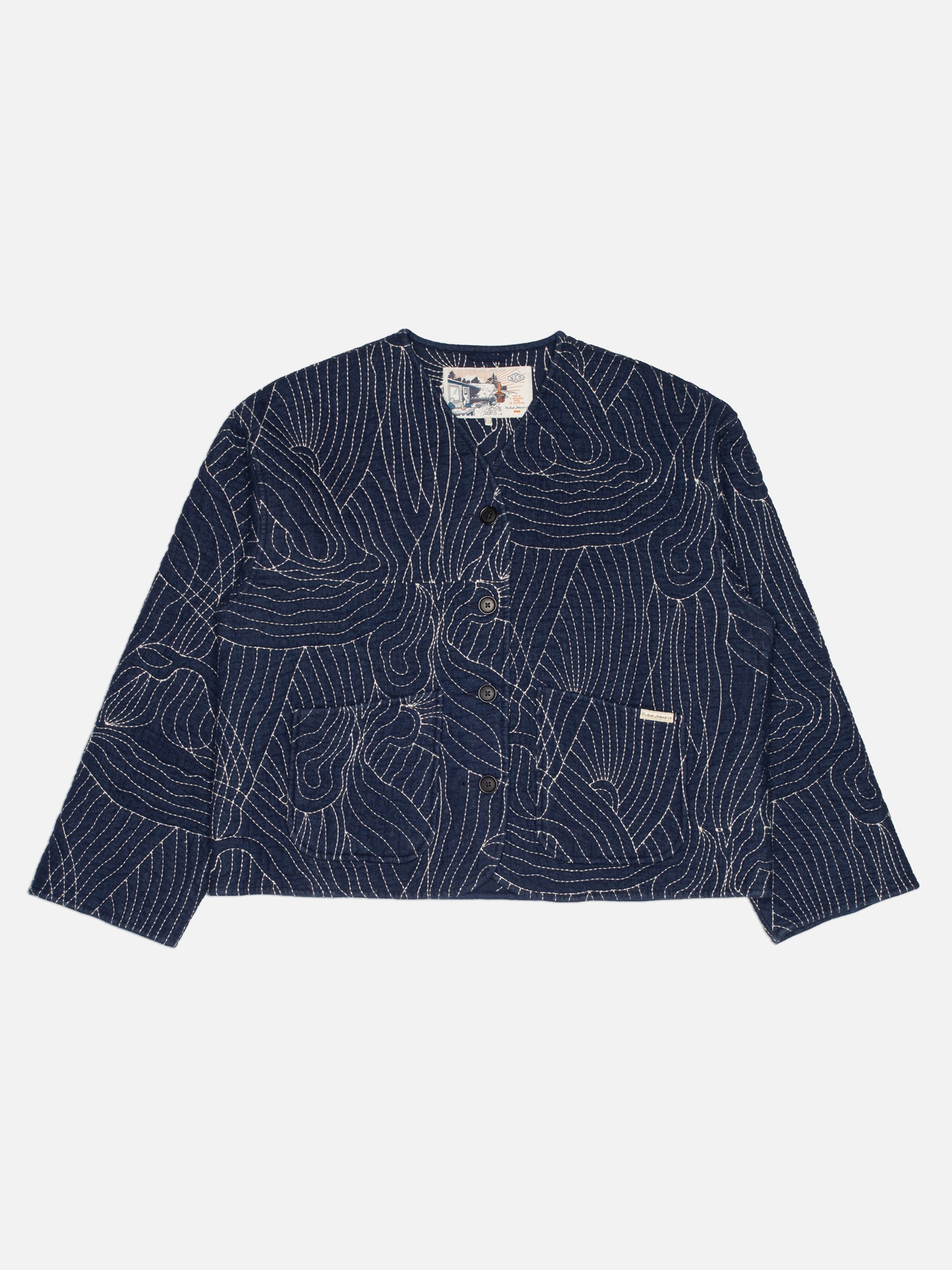Nudie Jeans Lena Jacket Indigo Quilt, gesteppte Jeansjacke aus Bio-Baumwolle in Indigo, flach ausgelegt.