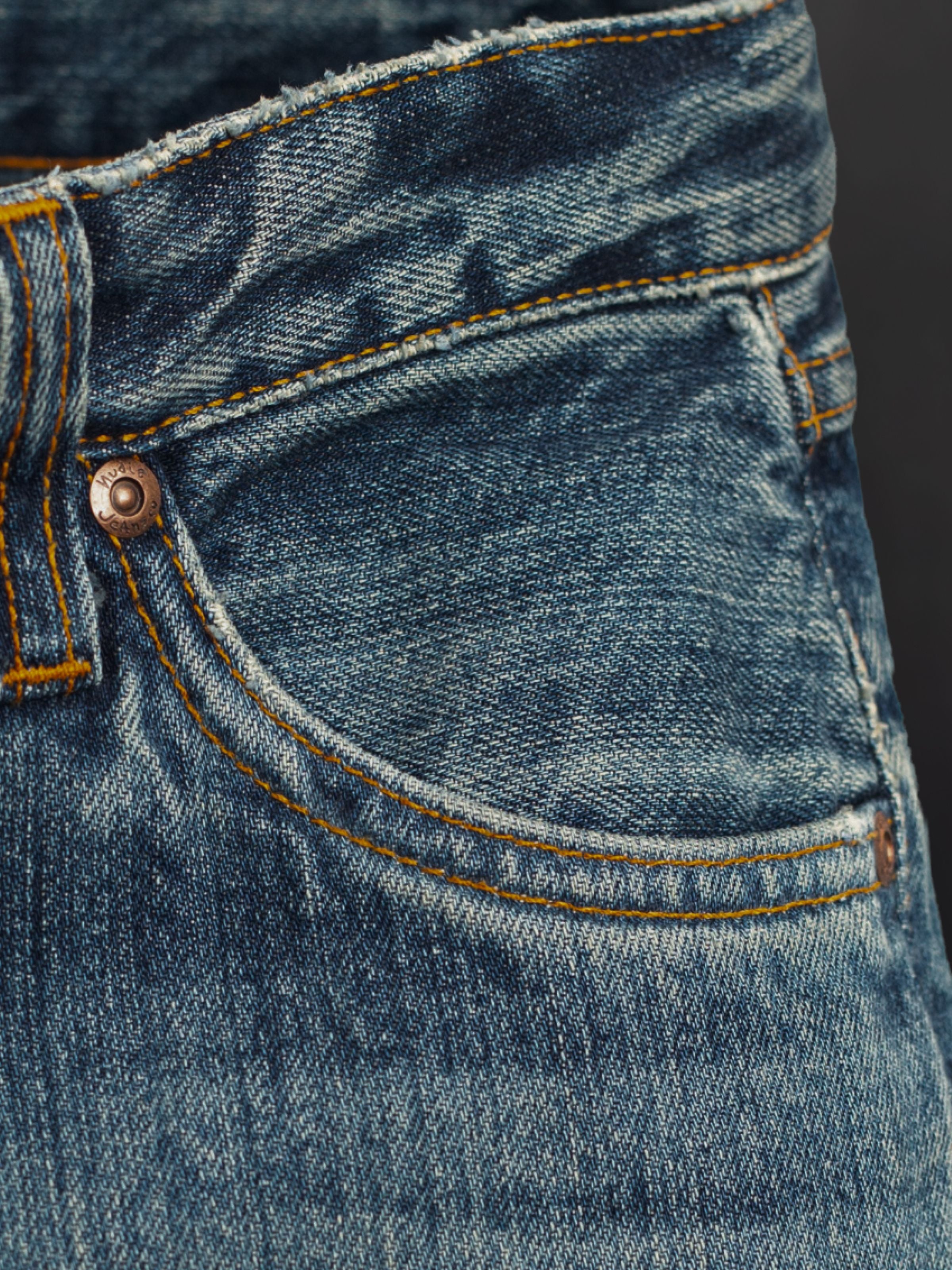 Nudie Jeans Dusty Dee Lineage Tracks, regular fit jeans, showing a close-up of the front pocket and washed denim texture.