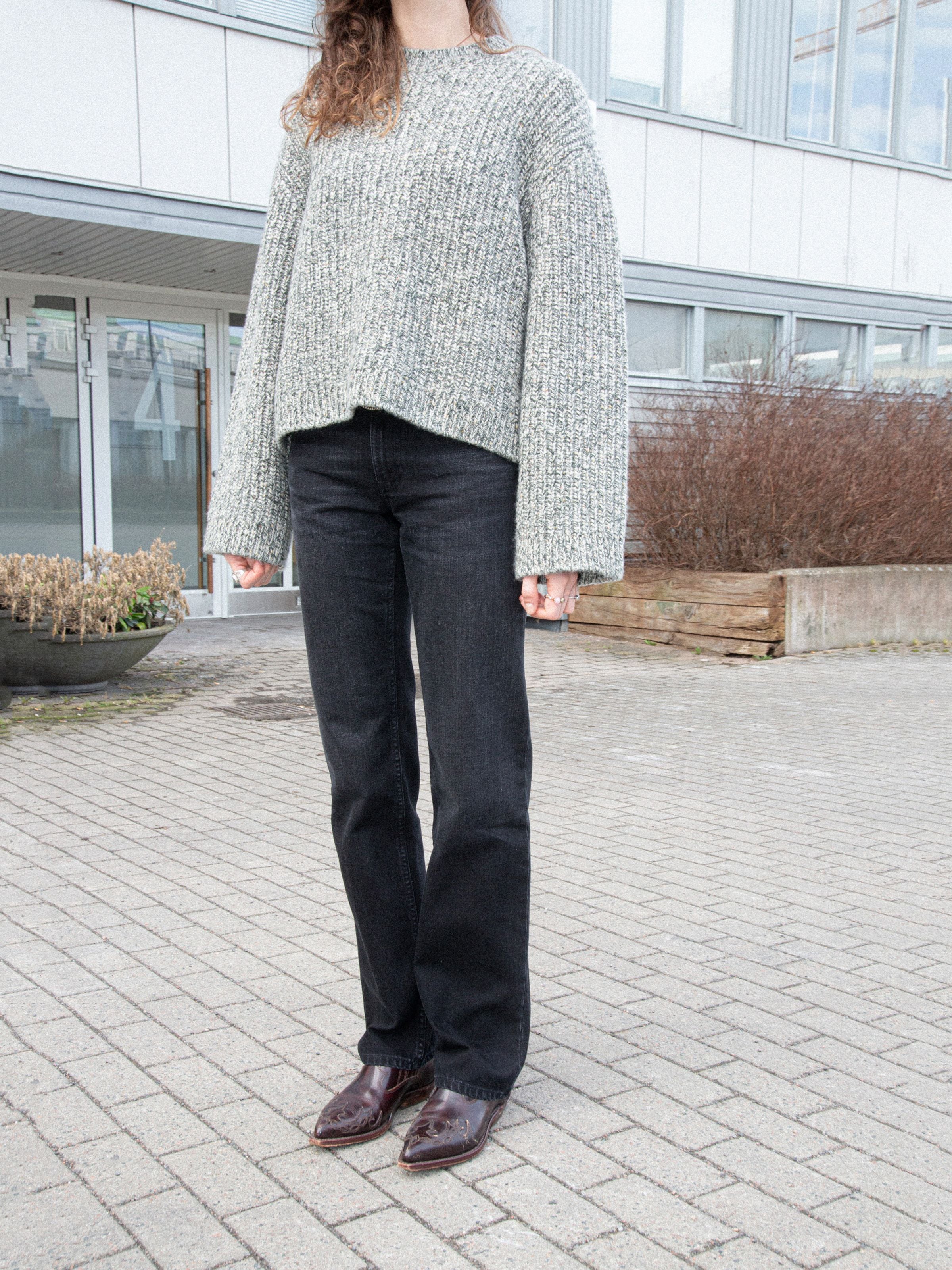 Nudie Jeans Sharp Charlie Midnight Ash, women's regular fit straight leg jeans in black, shown in a lifestyle shot outdoors.
