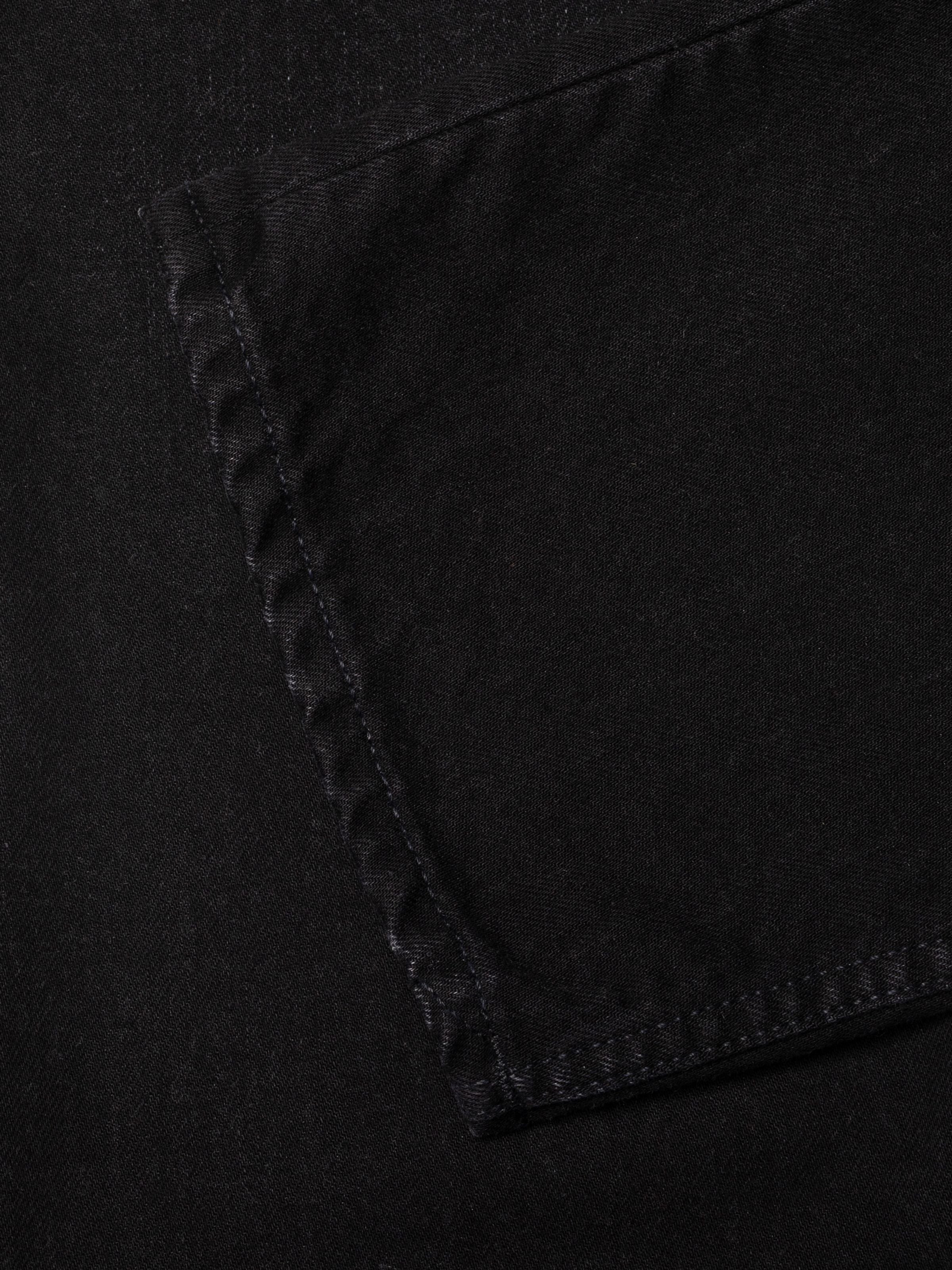 Nudie Jeans Sharp Charlie Midnight Ash, women's black jeans, showing a close-up of the pocket and black denim texture.