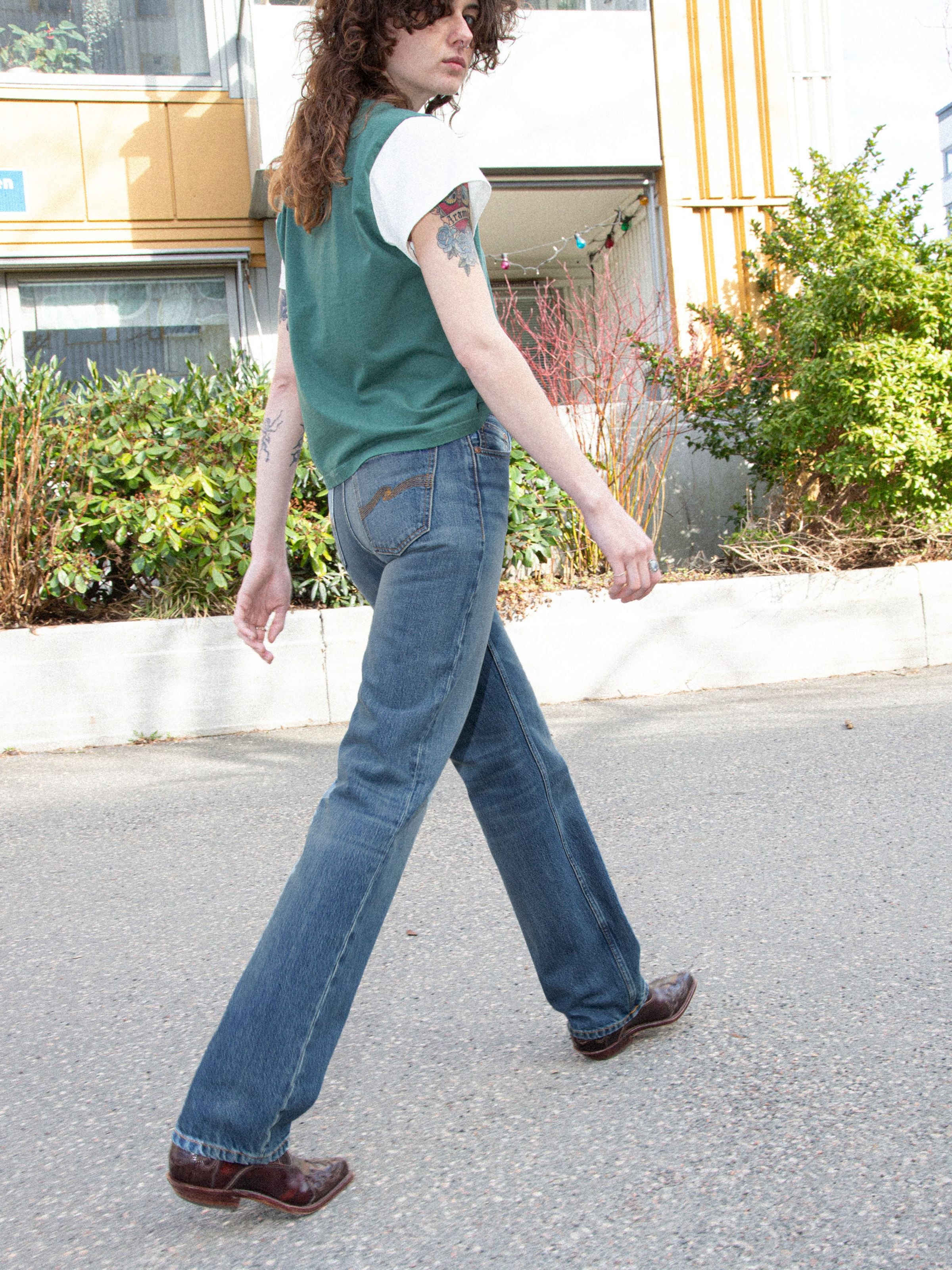 Nudie Jeans Sharp Charlie Gravel Stone, women's straight leg jeans in mid blue organic cotton denim, worn outdoors.