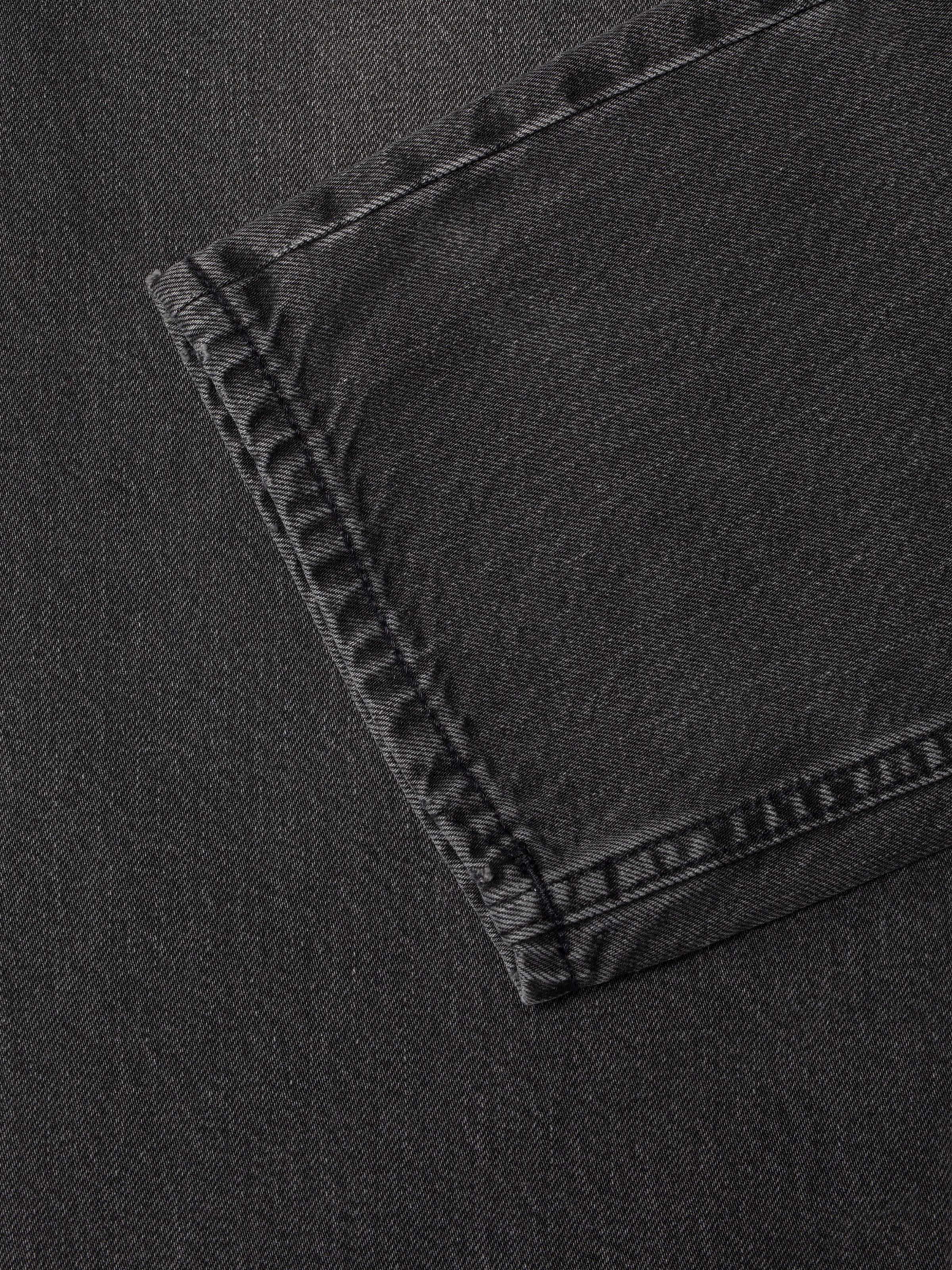 Nudie Jeans Rad Rufus Grey Lake, men's regular fit jeans, showing a close-up of the hem and grey wash denim texture.