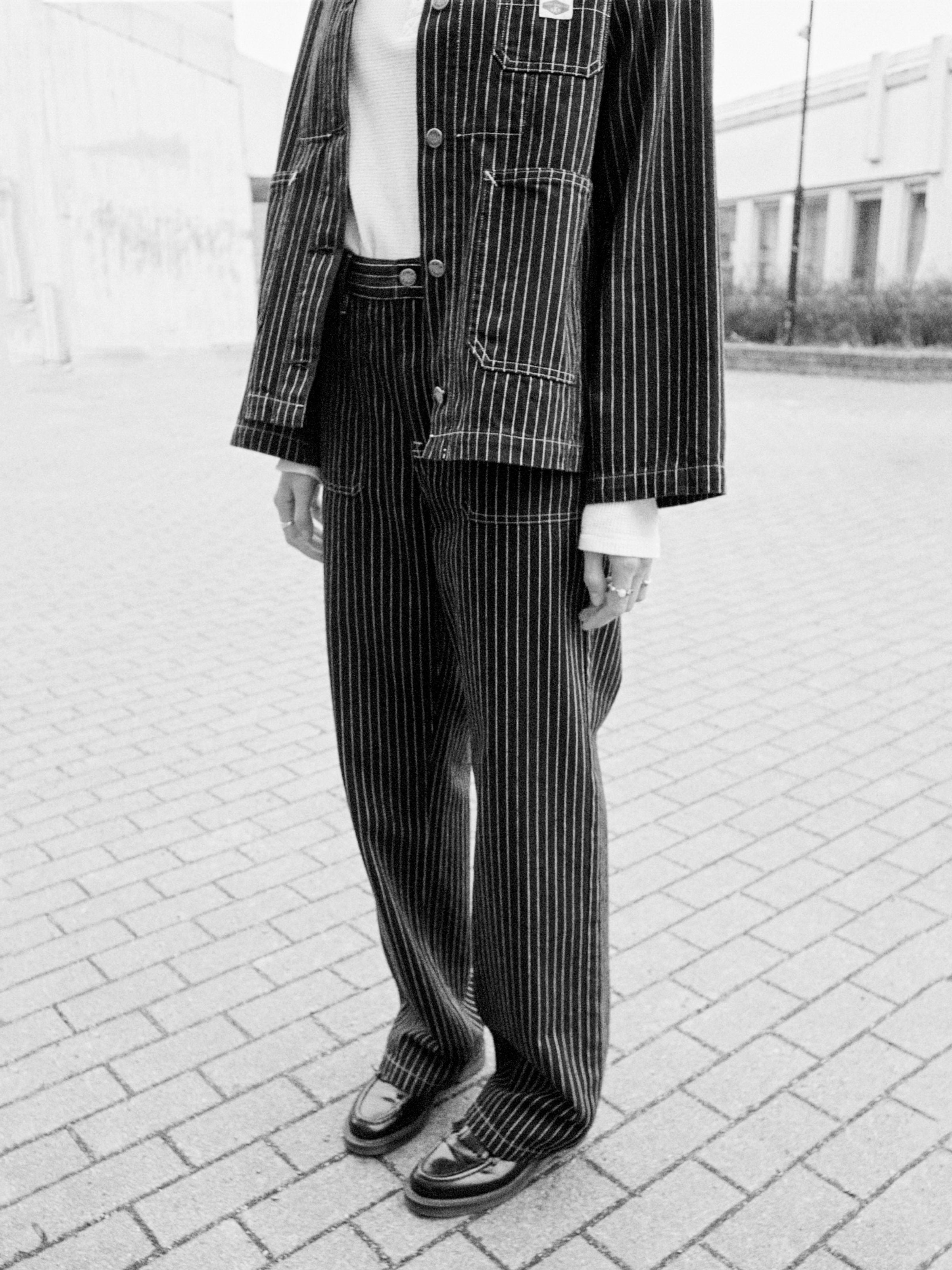 Nudie Jeans Asta Pants Pinstripe Denim, loose fit organic cotton pinstripe denim pants in a lifestyle context.