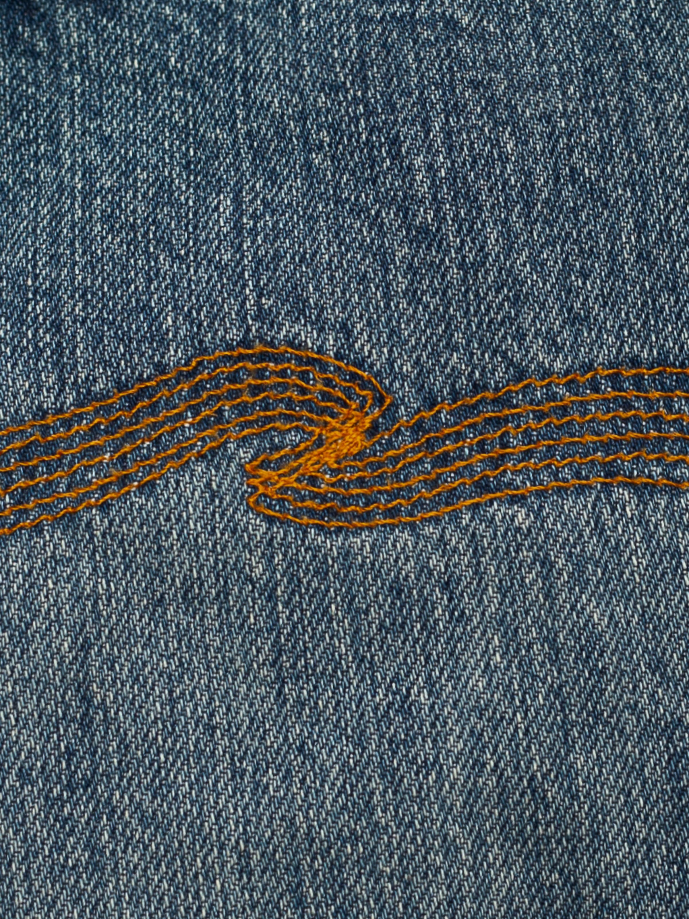 Nudie Jeans Tuff Tony Silver Tracks, Nahaufnahme der Gesäßtaschenstickerei.