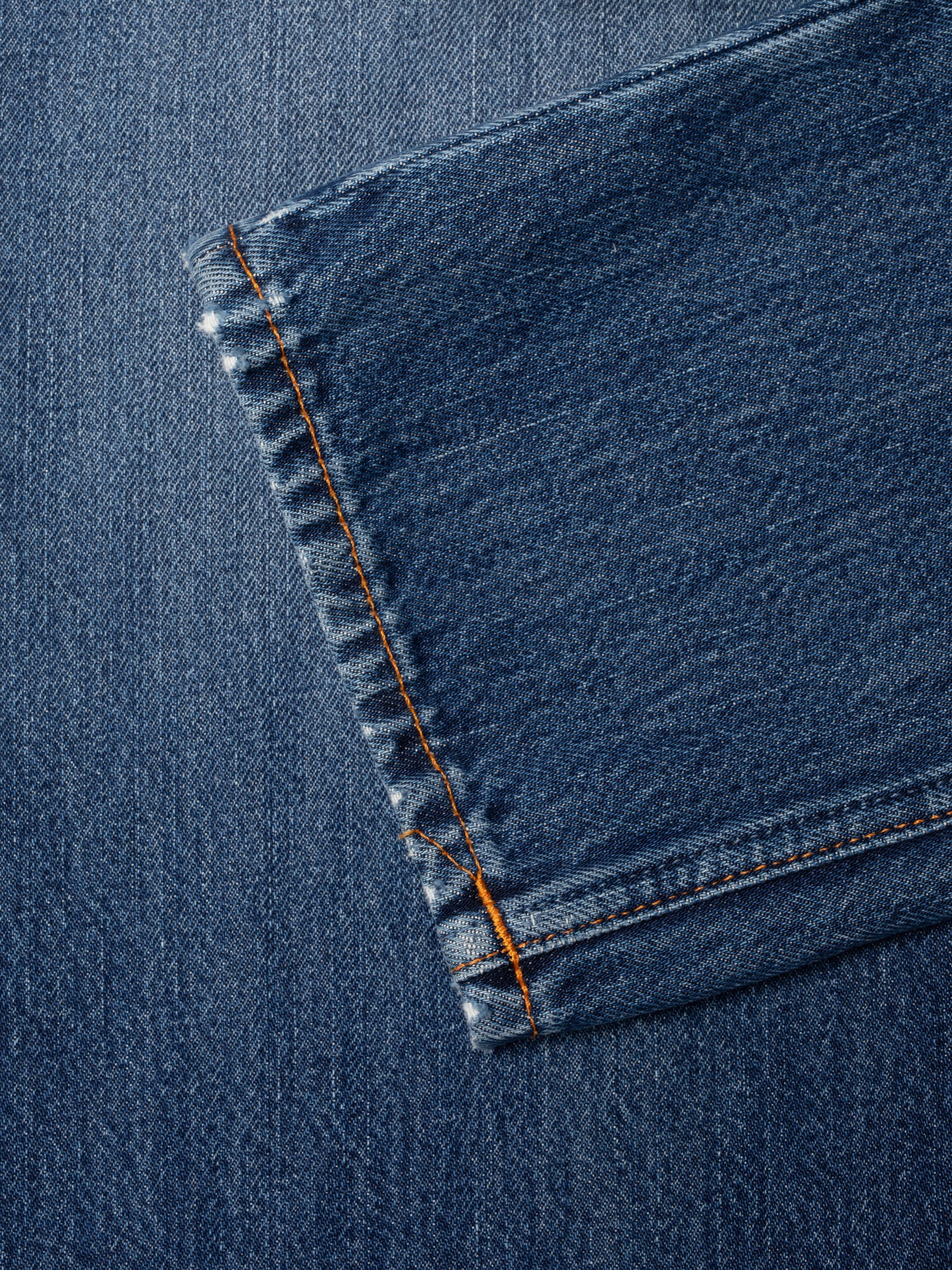 Nudie Jeans Steady Eddie II Rain River, showing a close-up of the hem and mid-blue denim texture.