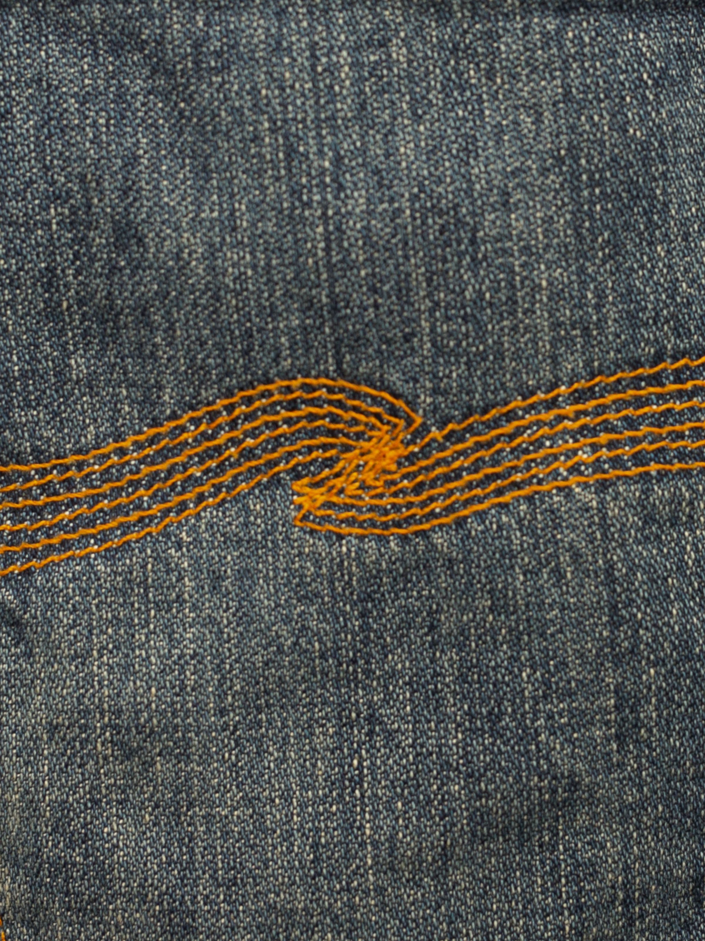 Nudie Jeans Steady Eddie II Quarter Tracks, close-up of back pocket embroidery and organic cotton denim texture.