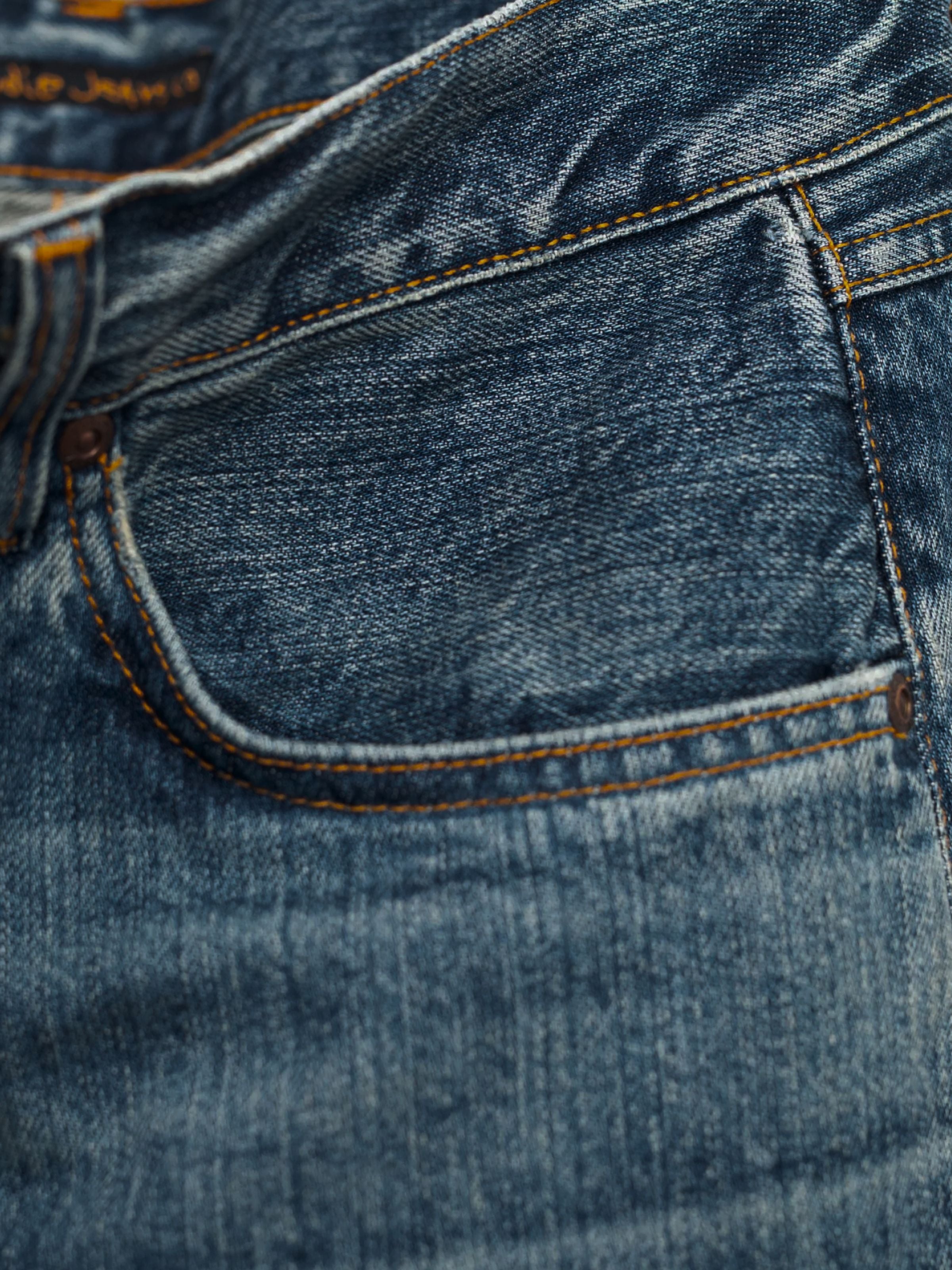 Nudie Jeans Rad Rufus Lineage Tracks, men's loose fit jeans, showing a close-up of the front pocket and washed denim texture.