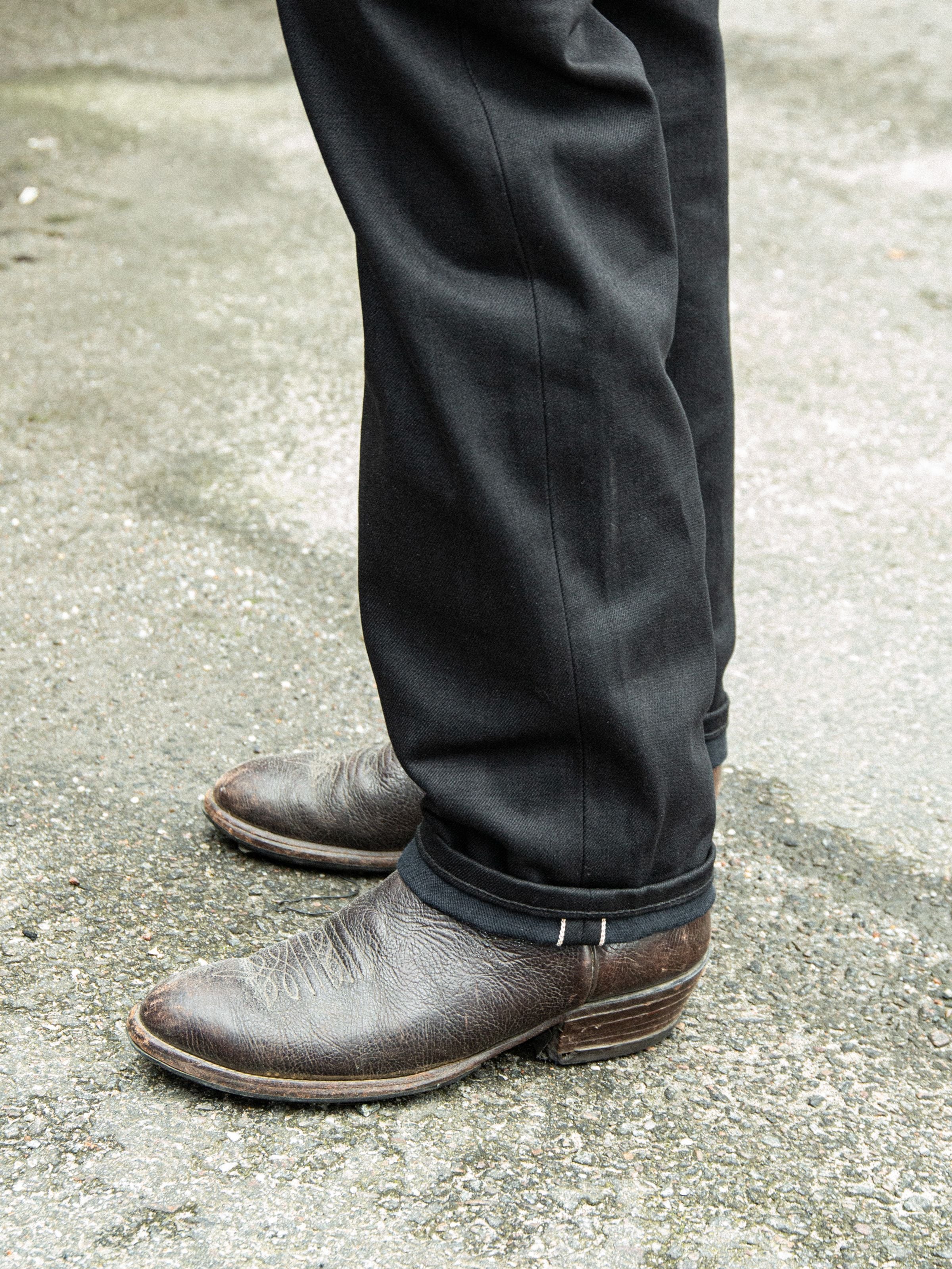 Nudie Jeans Rad Rufus Space Black Selvage, regular-fit jeans in black selvedge denim shown worn with boots.