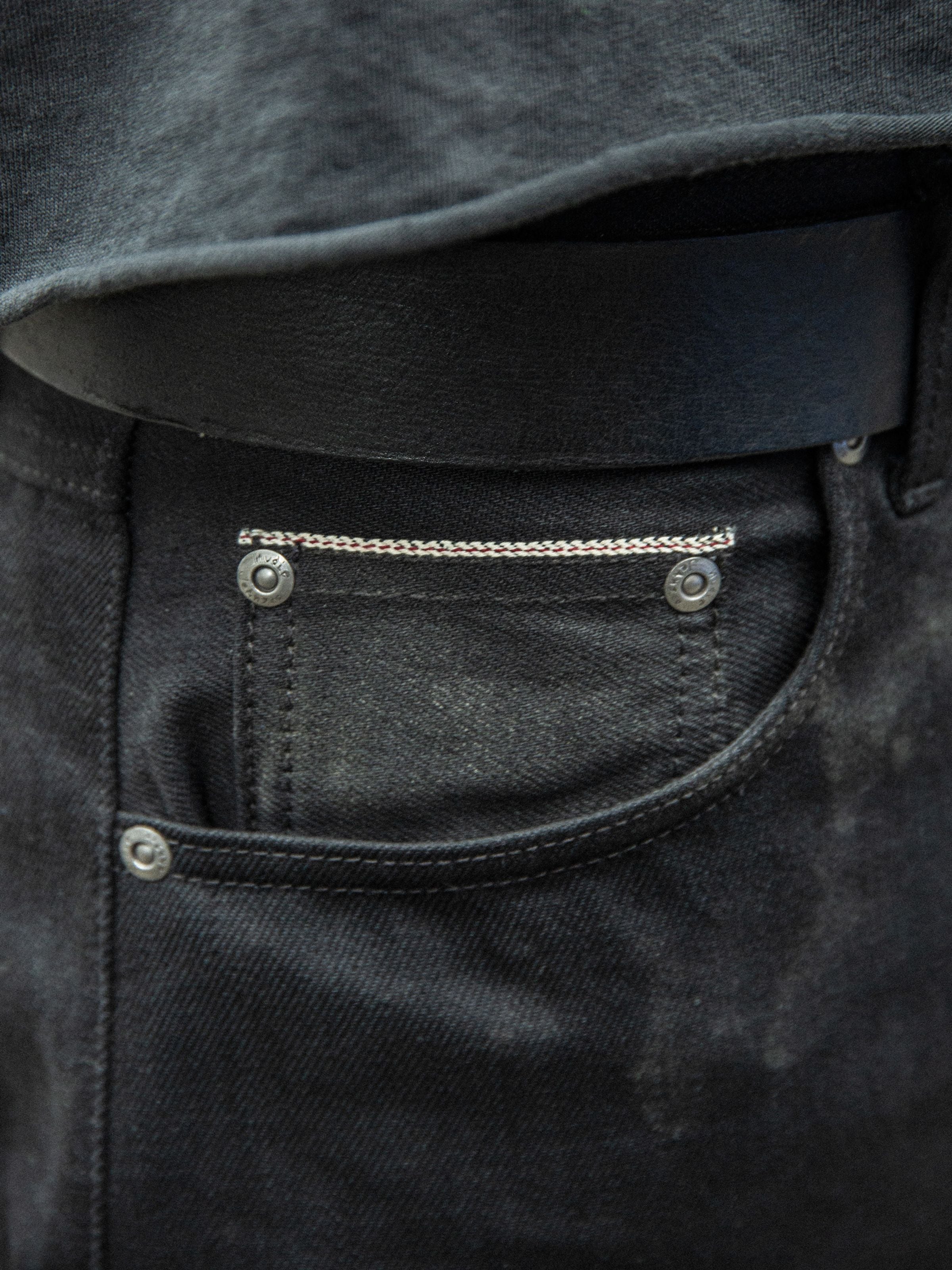 Nudie Jeans Rad Rufus Space Blk Selv, close-up of front pocket and black selvedge denim texture.