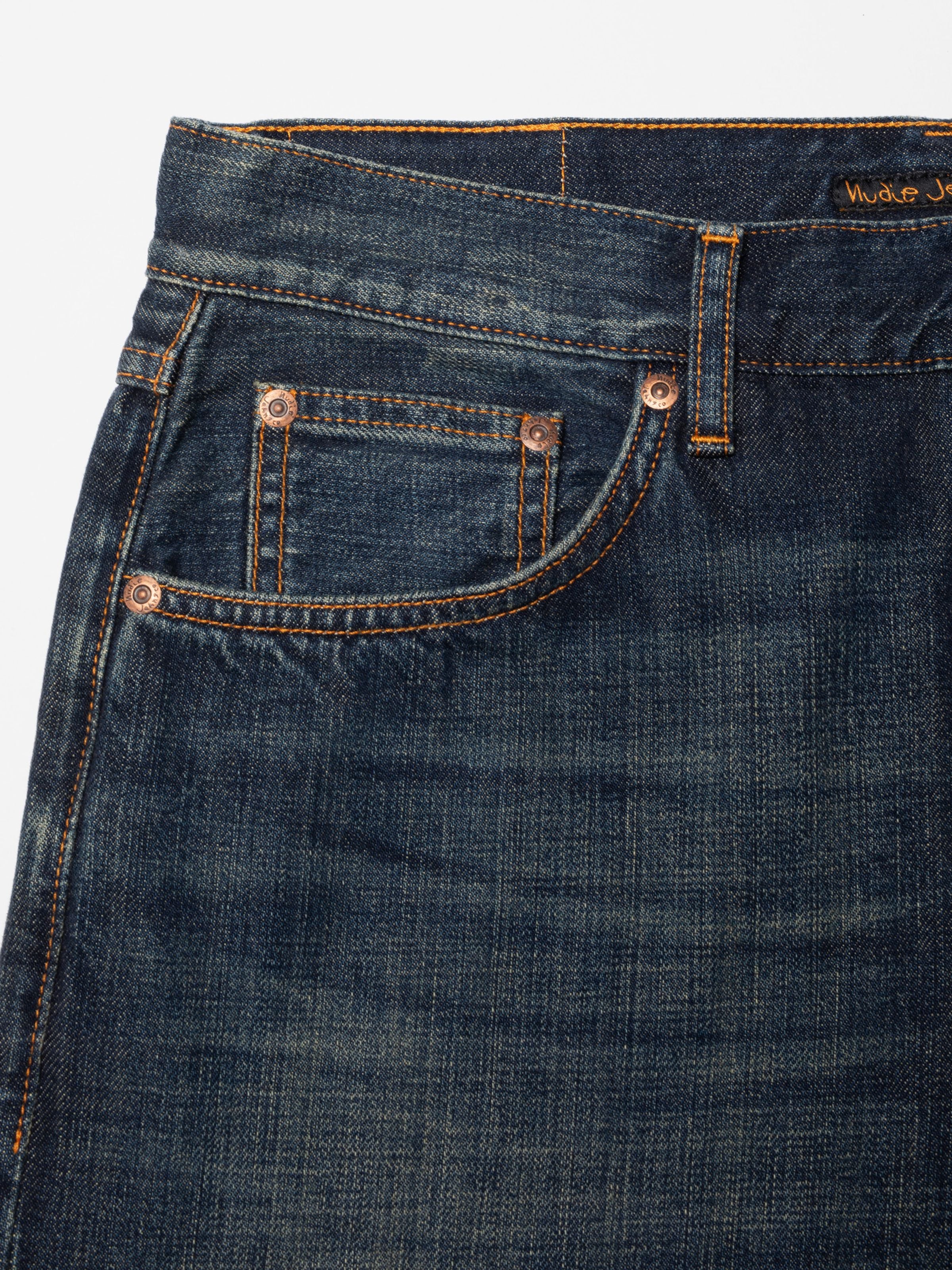 Nudie Jeans Tuff Tony Dirt Path, showing a close-up of the front pocket, copper trims, and washed denim texture.
