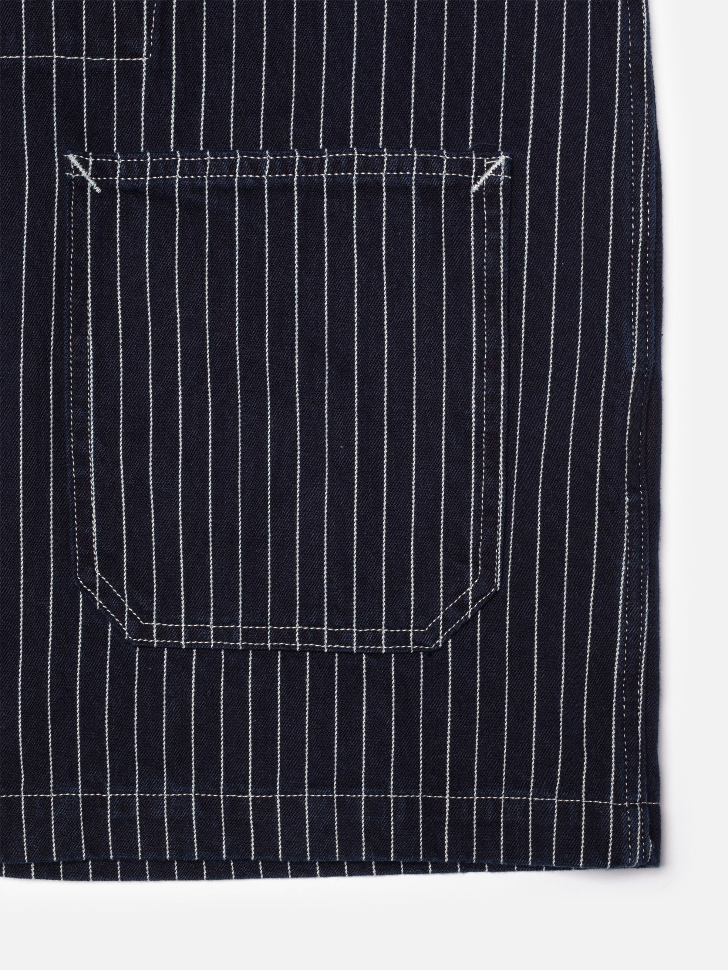 Nudie Jeans Ada Jacket Pinstripe Denim, showing a close-up of the front patch pocket and white pinstripe rigid denim texture.