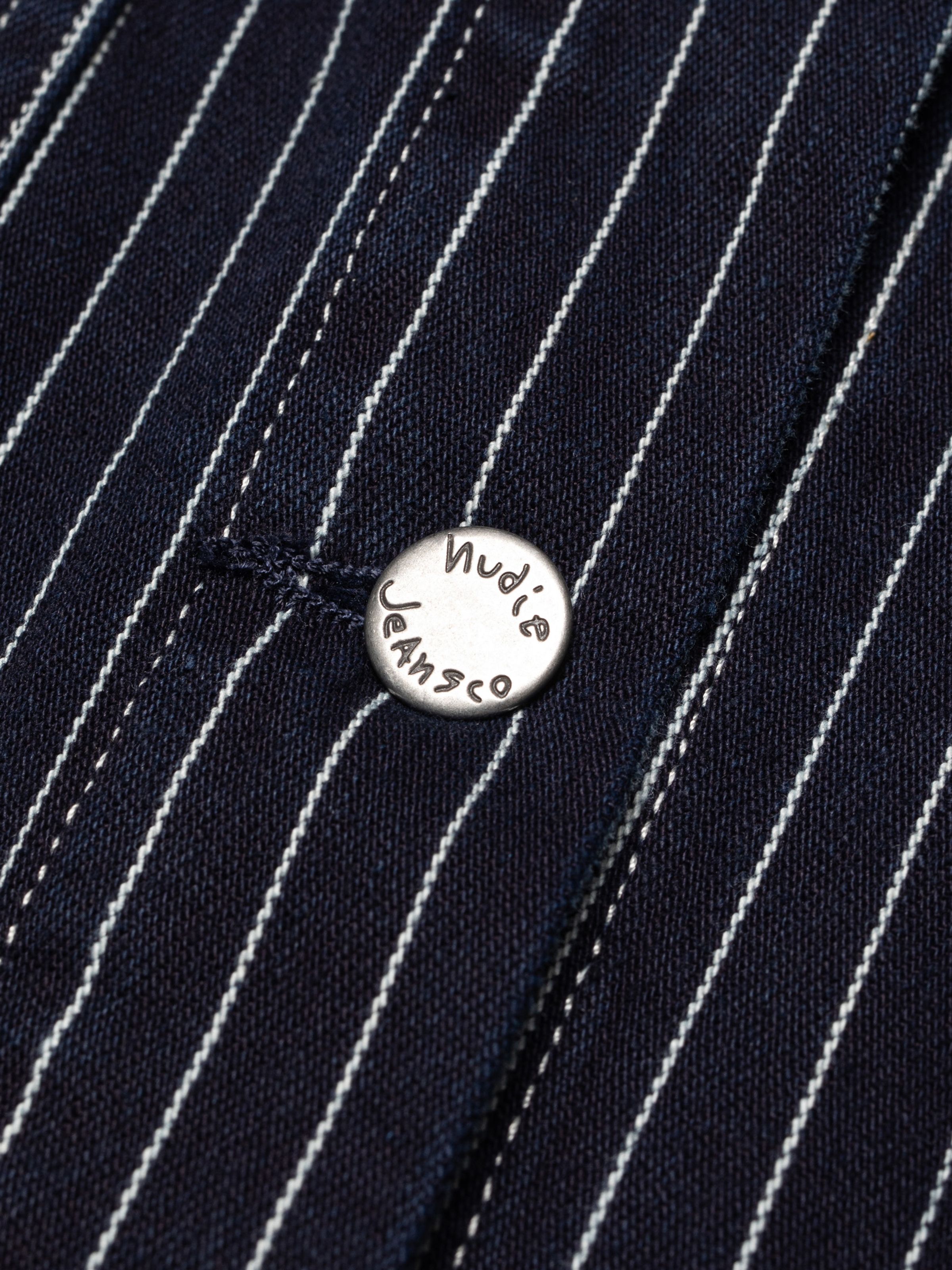 Nudie Jeans Ada Jacket Pinstripe Denim, showing a close-up of the metal button and pinstripe denim texture.