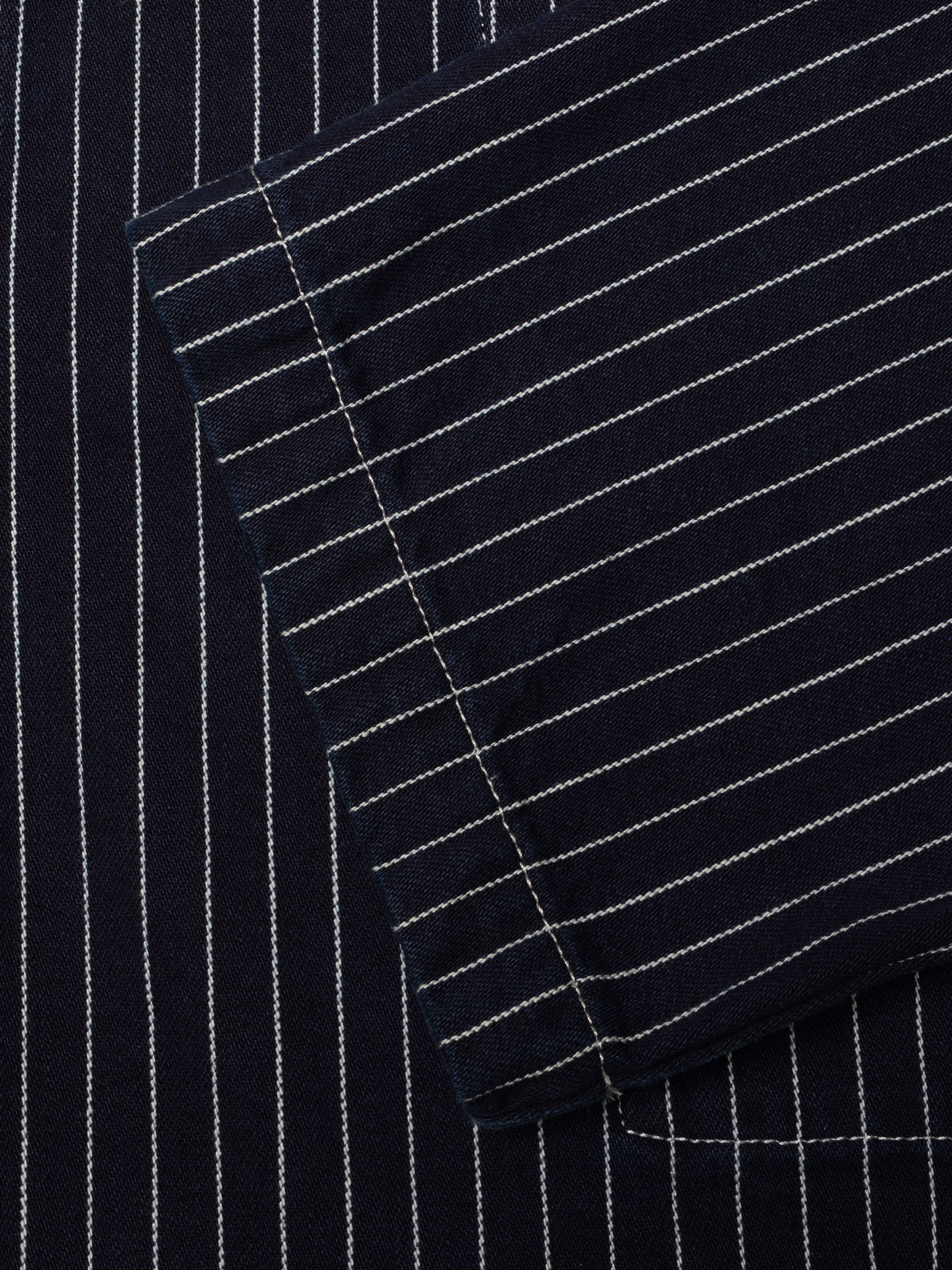 Nudie Jeans Ada Jacket Pinstripe Denim, showing a close-up of the blue and off-white pinstripe denim texture and stitching.