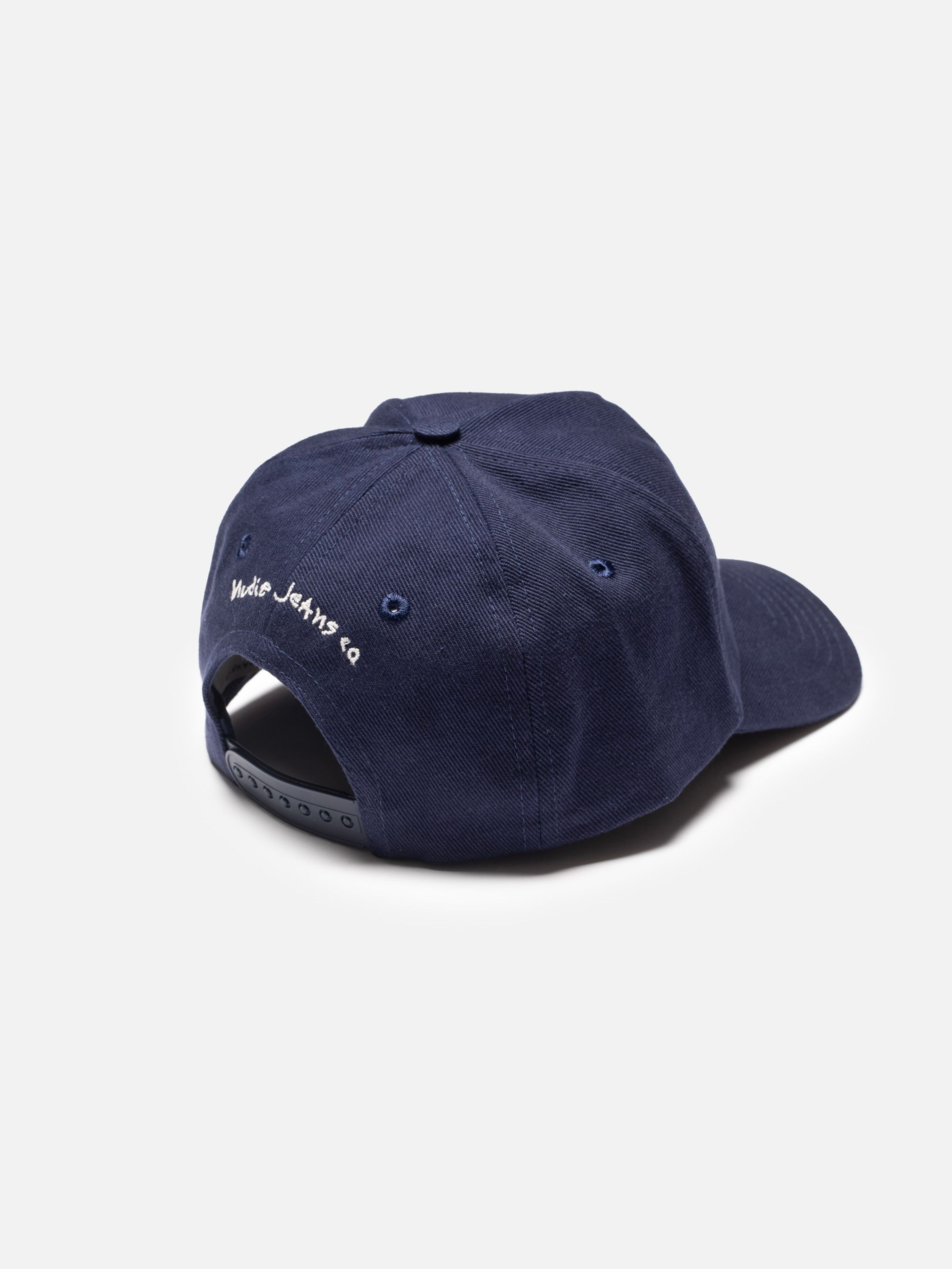 Nudie Cap Bad At Sports in navy blue, showing the back adjustable snapback strap and white embroidered logo.