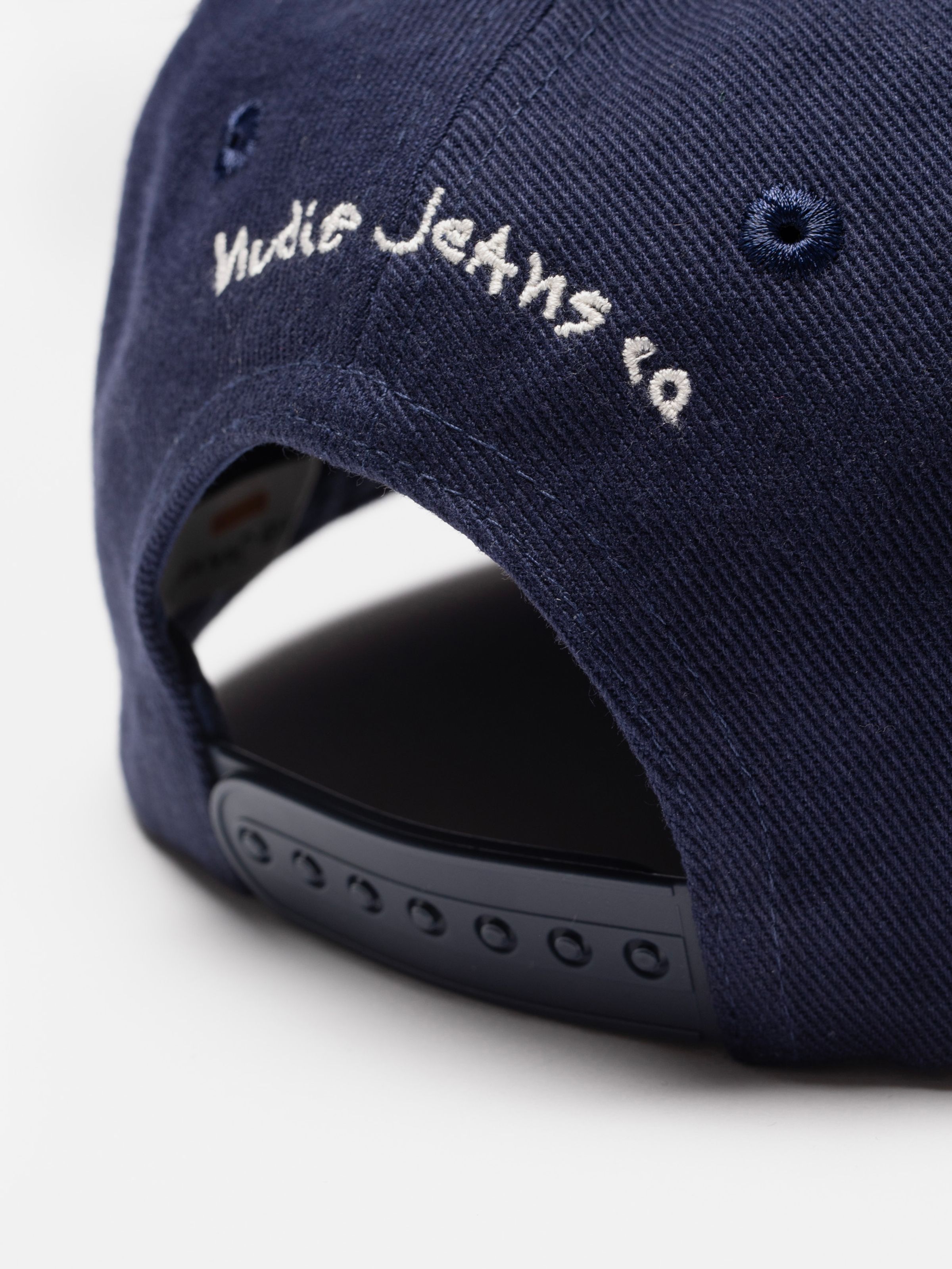 Nudie Cap Bad At Sports in Blue, close-up of the back featuring white embroidered branding and a snapback closure.