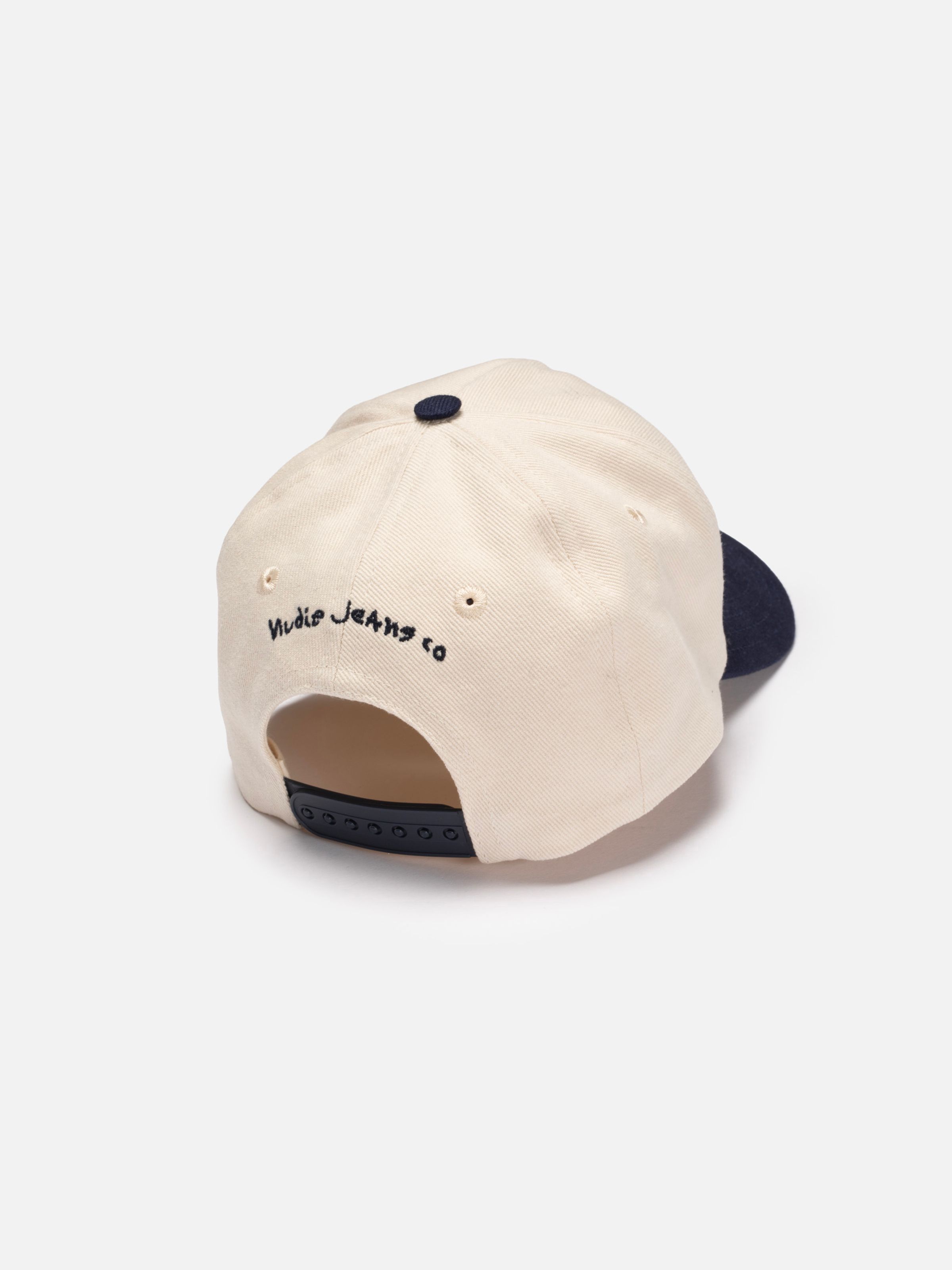 Nudie Cap Embo in Offwhite, featuring navy Nudie Jeans co embroidery and an adjustable snapback closure from the back.