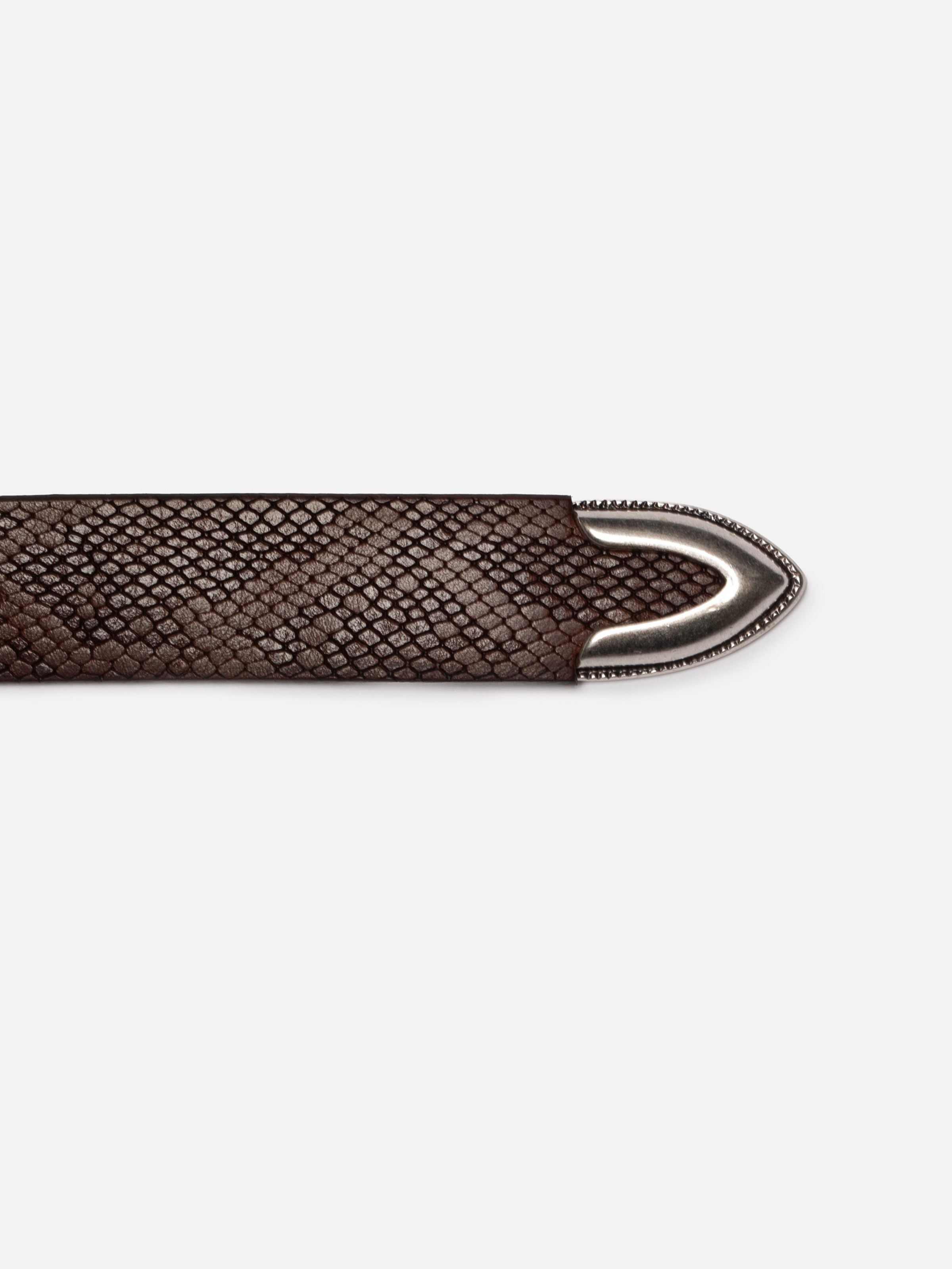 Nudie Jeans Western Faux Snake Silver Belt in Dark Brown, close-up of the dark brown reptile embossed leather and silver tip.