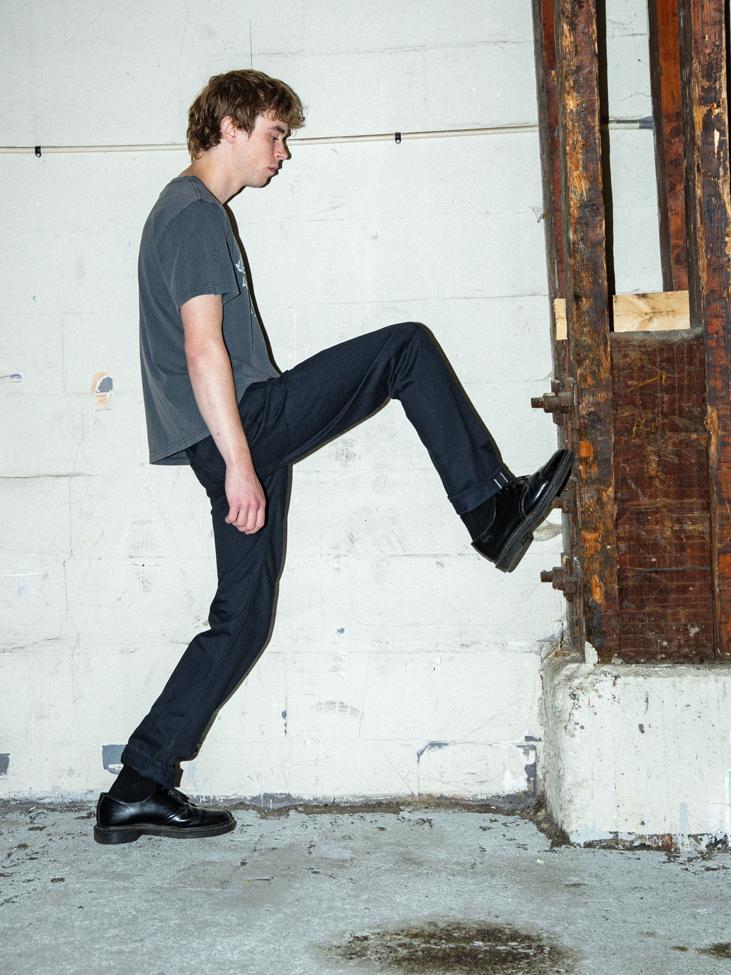 Nudie Jeans Gritty Jackson Dry Onyx Selvedge, men's selvedge jeans in black, worn by a model in an indoor setting.