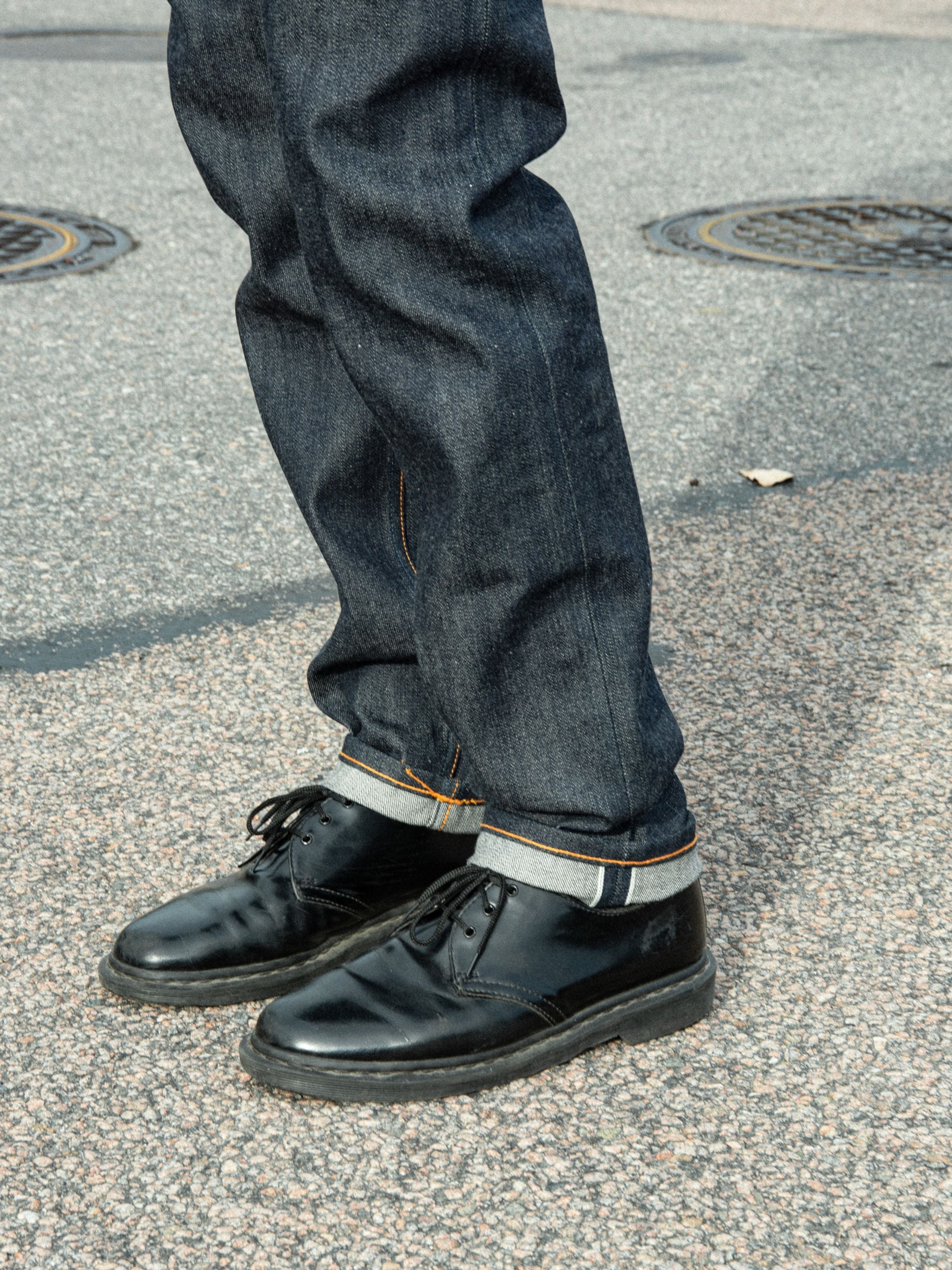 Nudie Jeans Solid Ollie Dry Apex Selvage, slim fit selvedge jeans in blue organic cotton stretch denim worn outdoors.