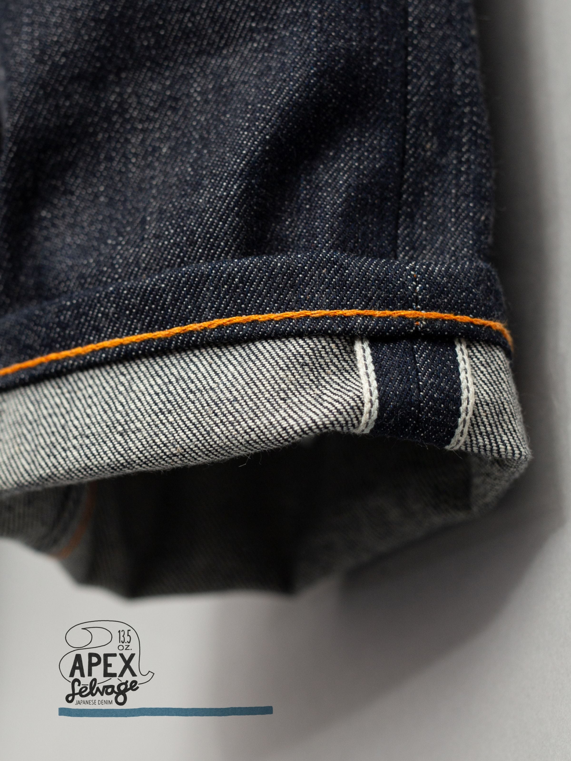 Nudie Jeans Solid Ollie Dry Apex Selvage, close-up of the cuffed hem showing the deep indigo selvedge denim texture.