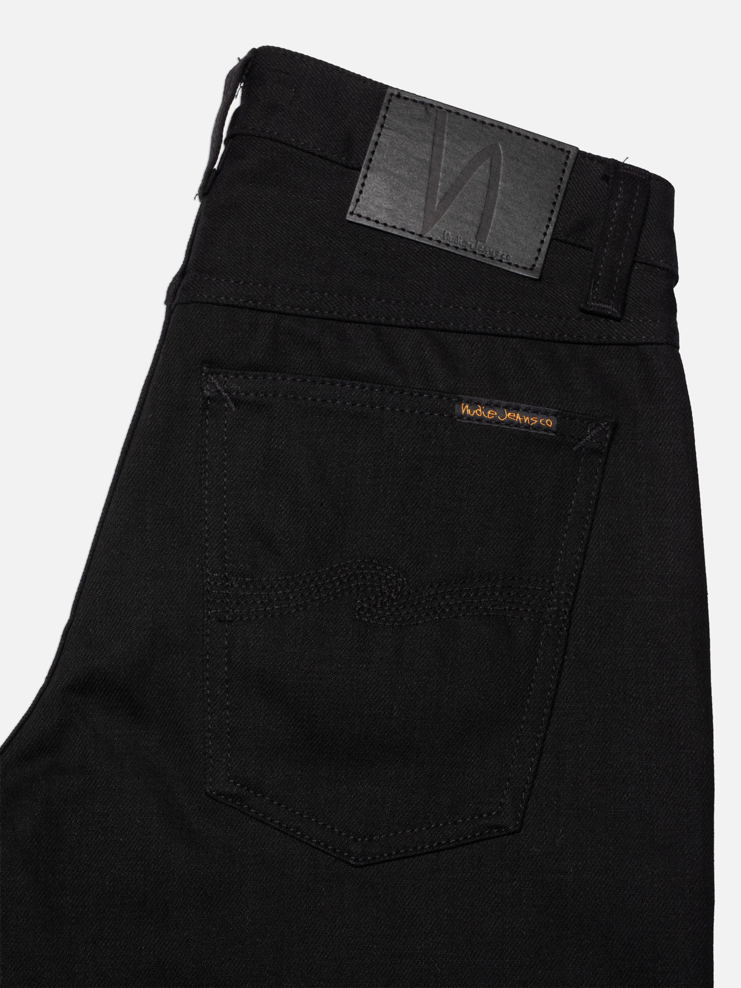 Nudie Jeans Sharp Charlie Space Black Selvedge, regular fit jeans, showing a close-up of the back pocket and jacron patch.