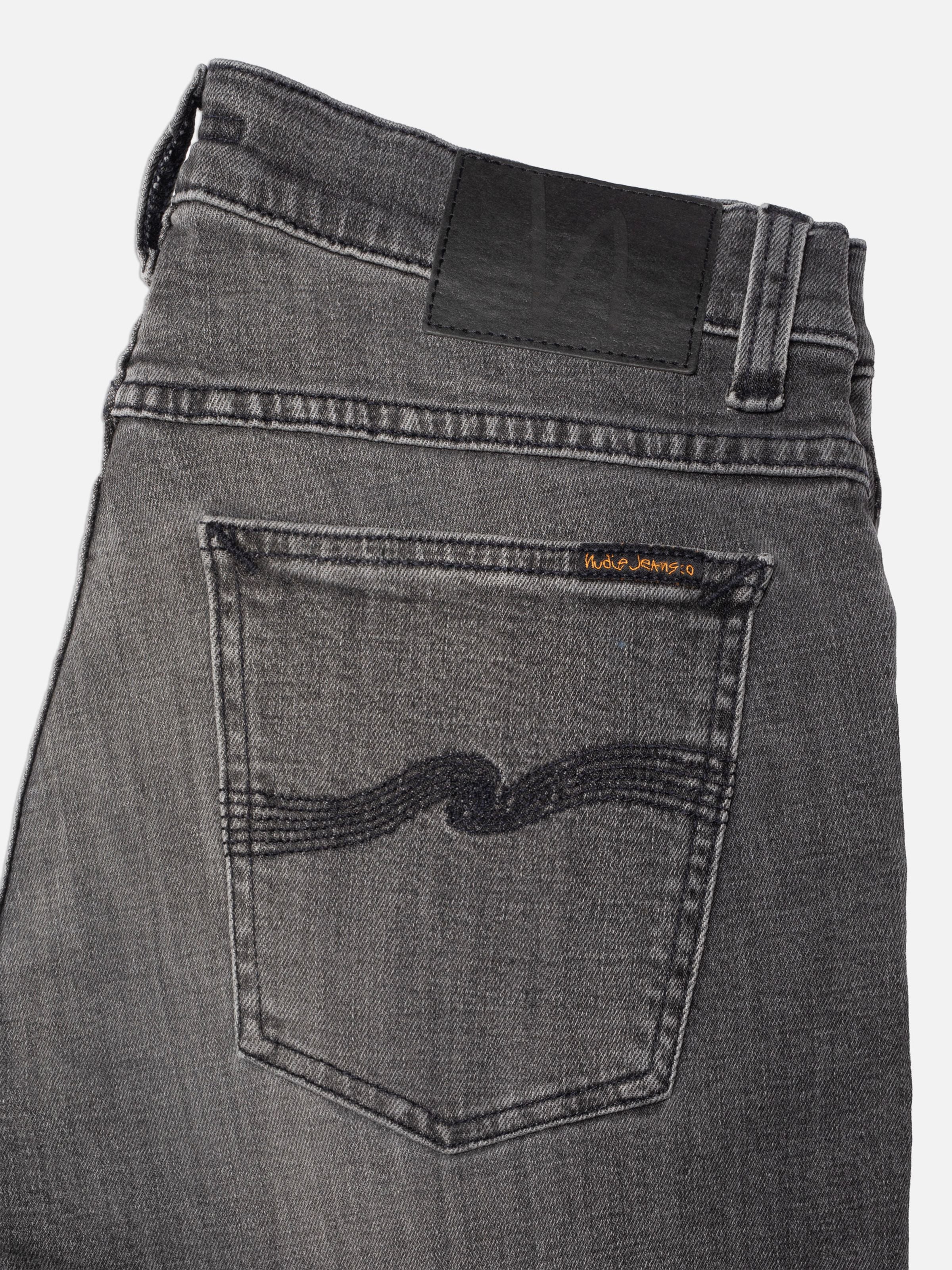 Nudie Jeans Tight Terry Grey Lava, organic cotton jeans, close-up of back pocket, patch, and grey wash texture.