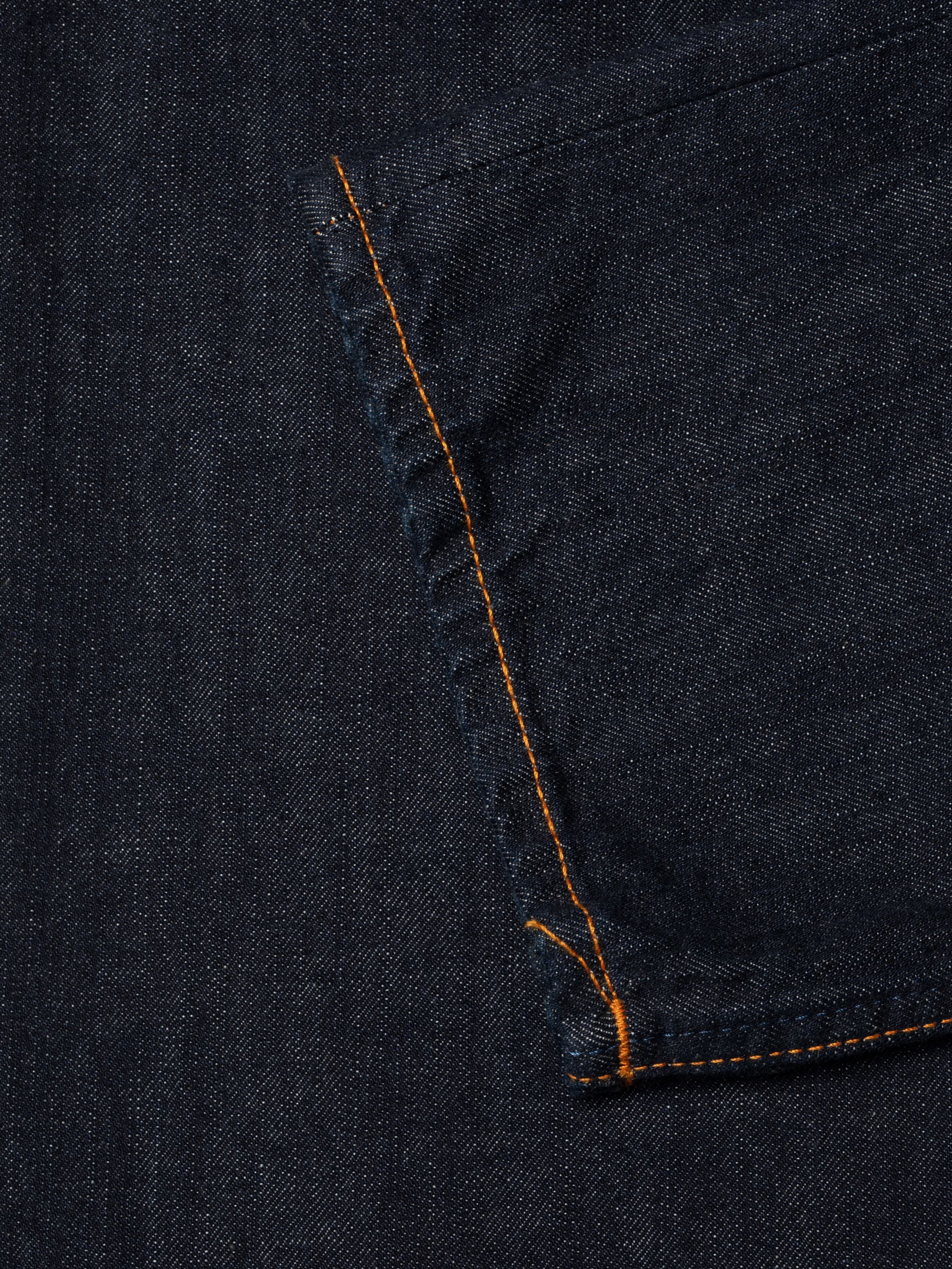 Nudie Jeans Sharp Charlie Blue One Wash, showing a close-up of the dark blue denim texture and orange thread at seams.