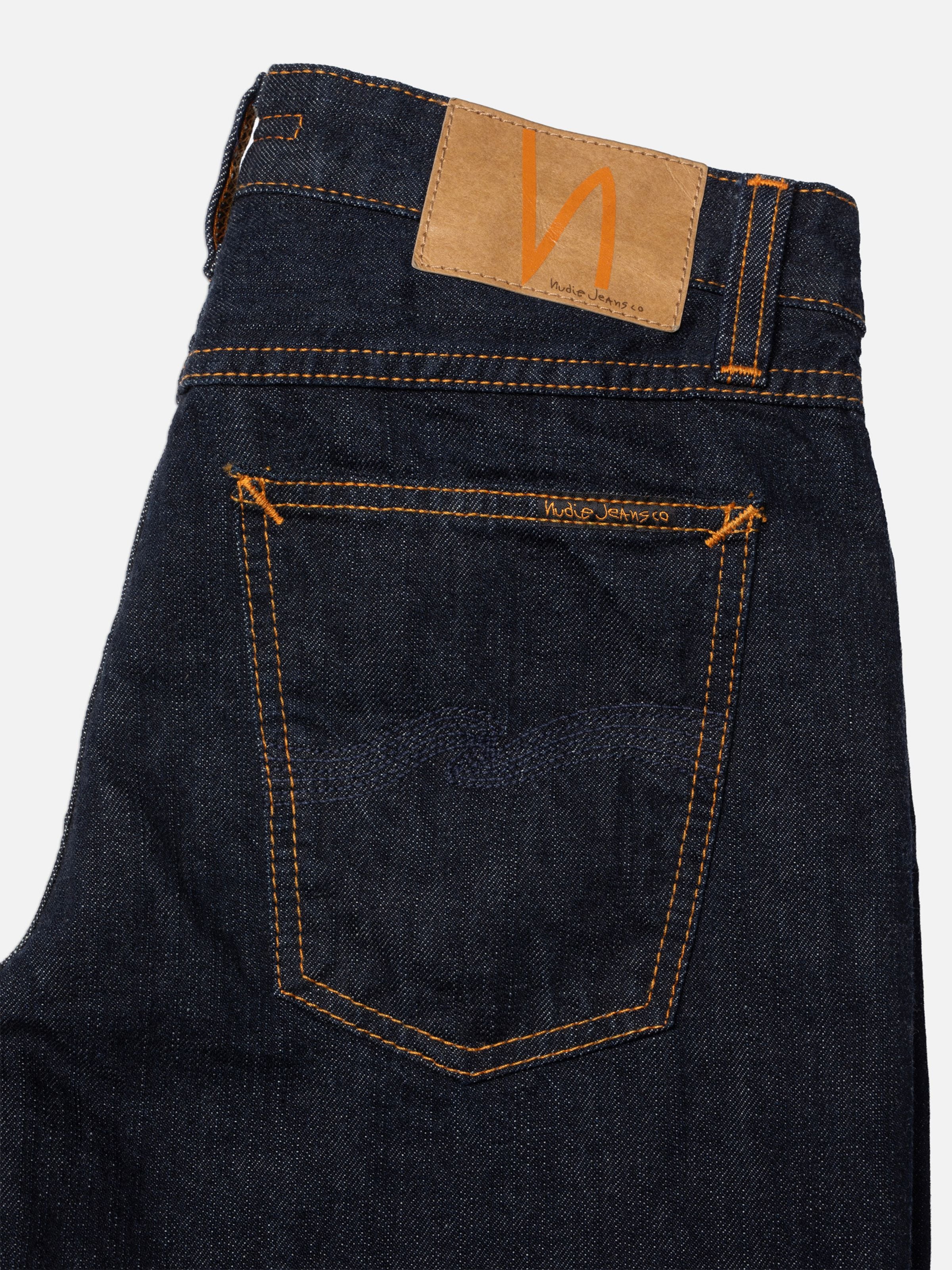 Nudie Jeans Sharp Charlie Blue One Wash, close-up of back pocket, jacron patch, and orange seams.