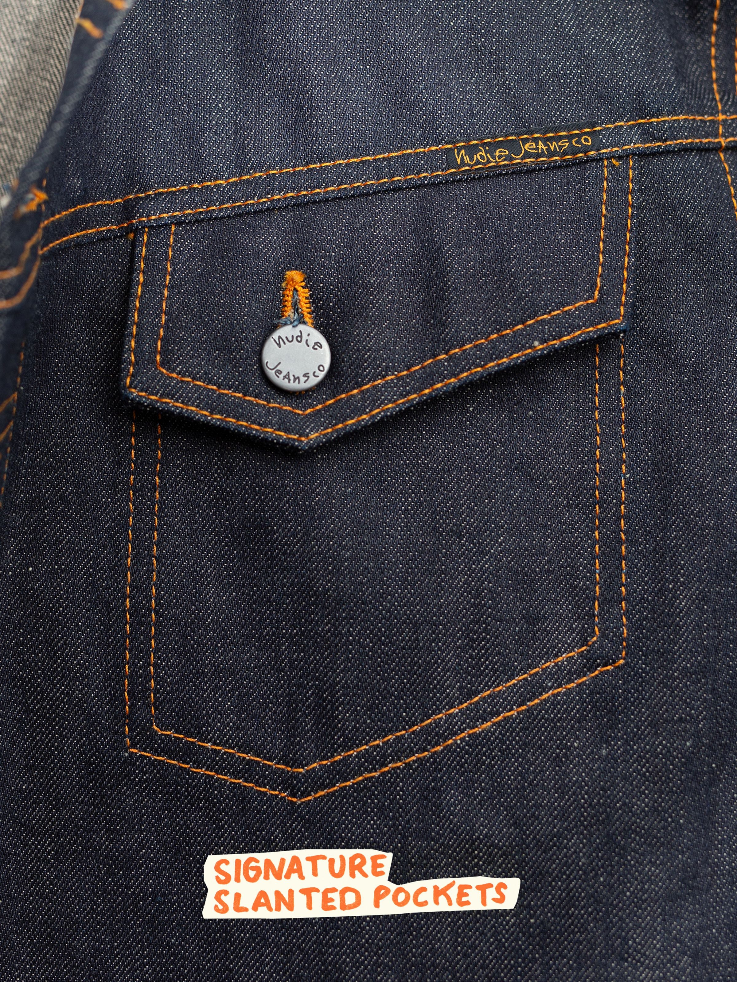 Nudie Jeans Conny Denim Jacket Dry Selvage, Nahaufnahme der Brusttasche und der dunklen Indigo Selvedge Denim Textur.