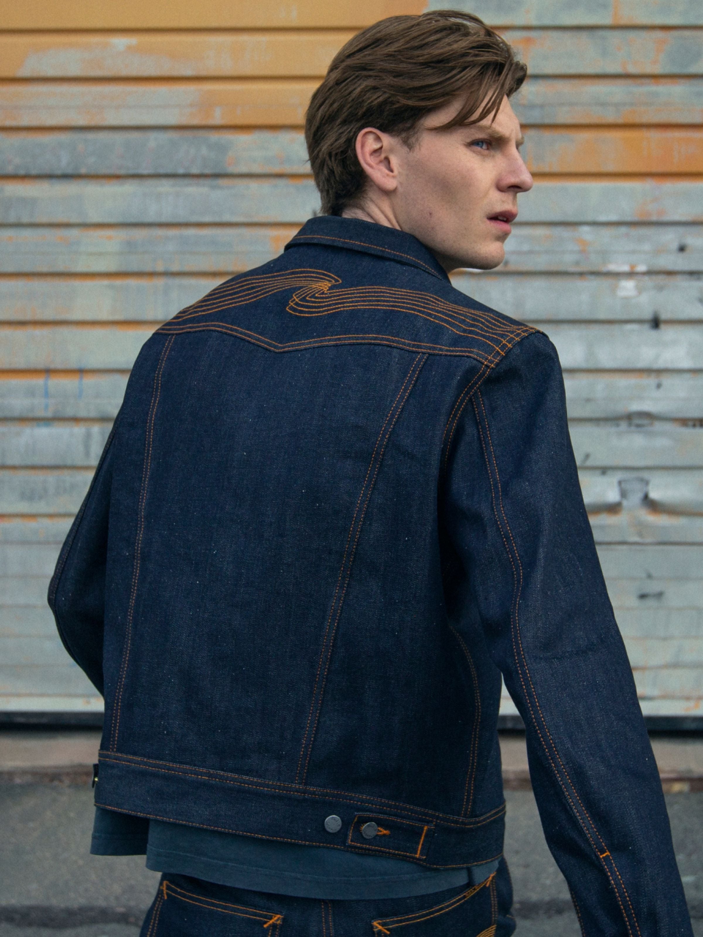 Nudie Jeans Conny Denim Jacket in Dry Selvedge, Lifestyle-Aufnahme der Rückenpasse mit Stickerei aus starrem Denim.