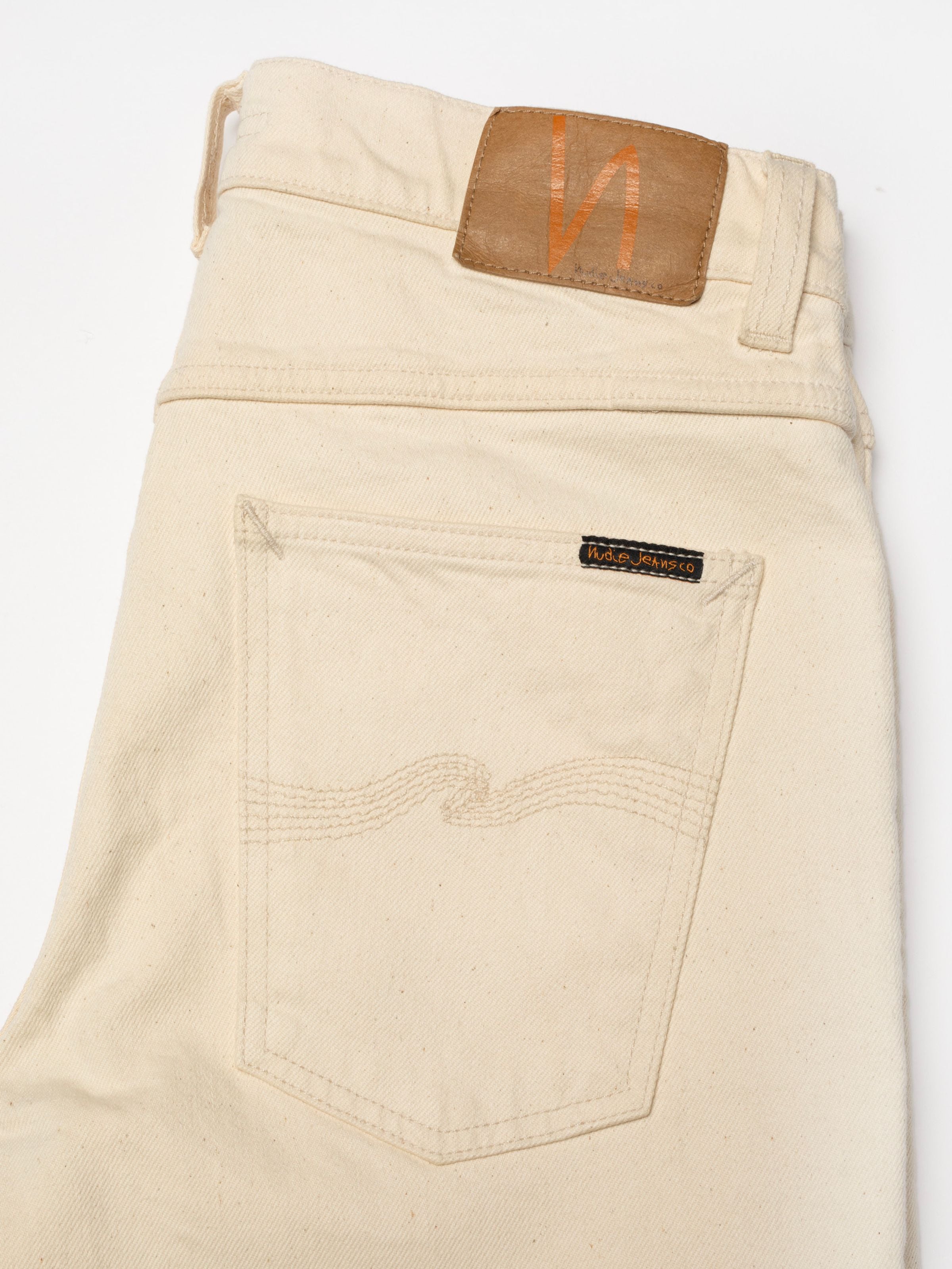 Nudie Jeans Lean Dean Ivory, a close-up of the back pocket and Jacron patch on textured ivory organic cotton stretch denim.
