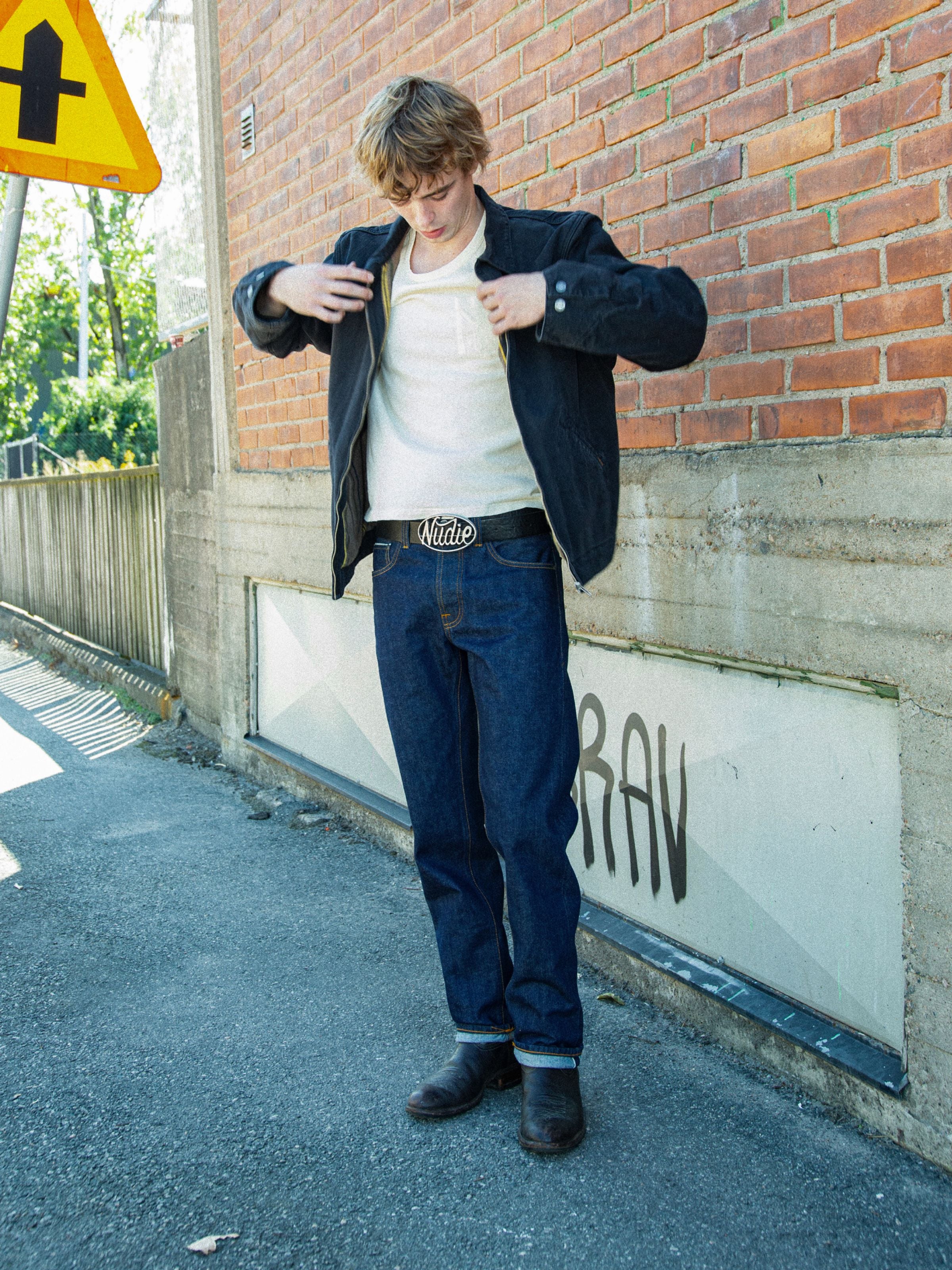 Nudie Jeans Rad Rufus Dusk Selvage One Wash, men's regular fit selvedge jeans worn outdoors against a brick wall.