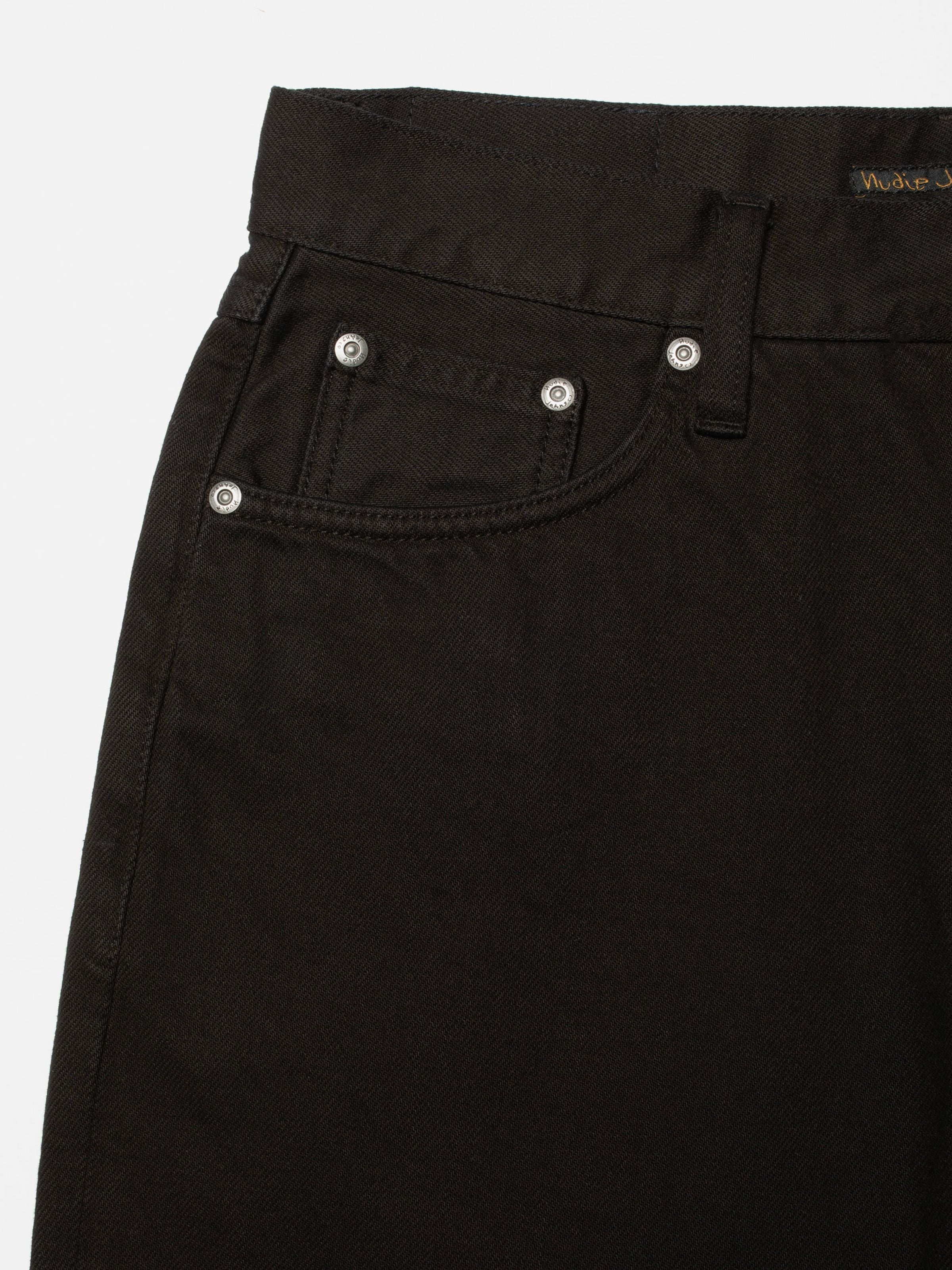 Nudie Jeans Rad Rufus Deep Black, close-up of the front coin pocket and silver rivets on black organic cotton denim.