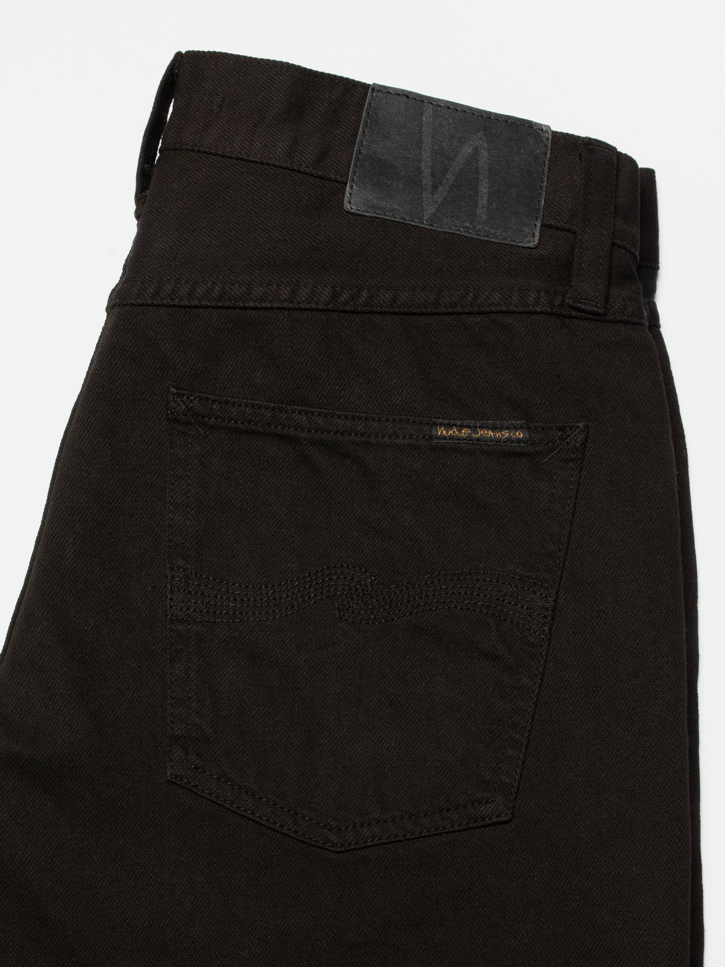 Nudie Jeans Rad Rufus Deep Black, close-up of the back pocket and leather patch on rigid organic cotton jeans.