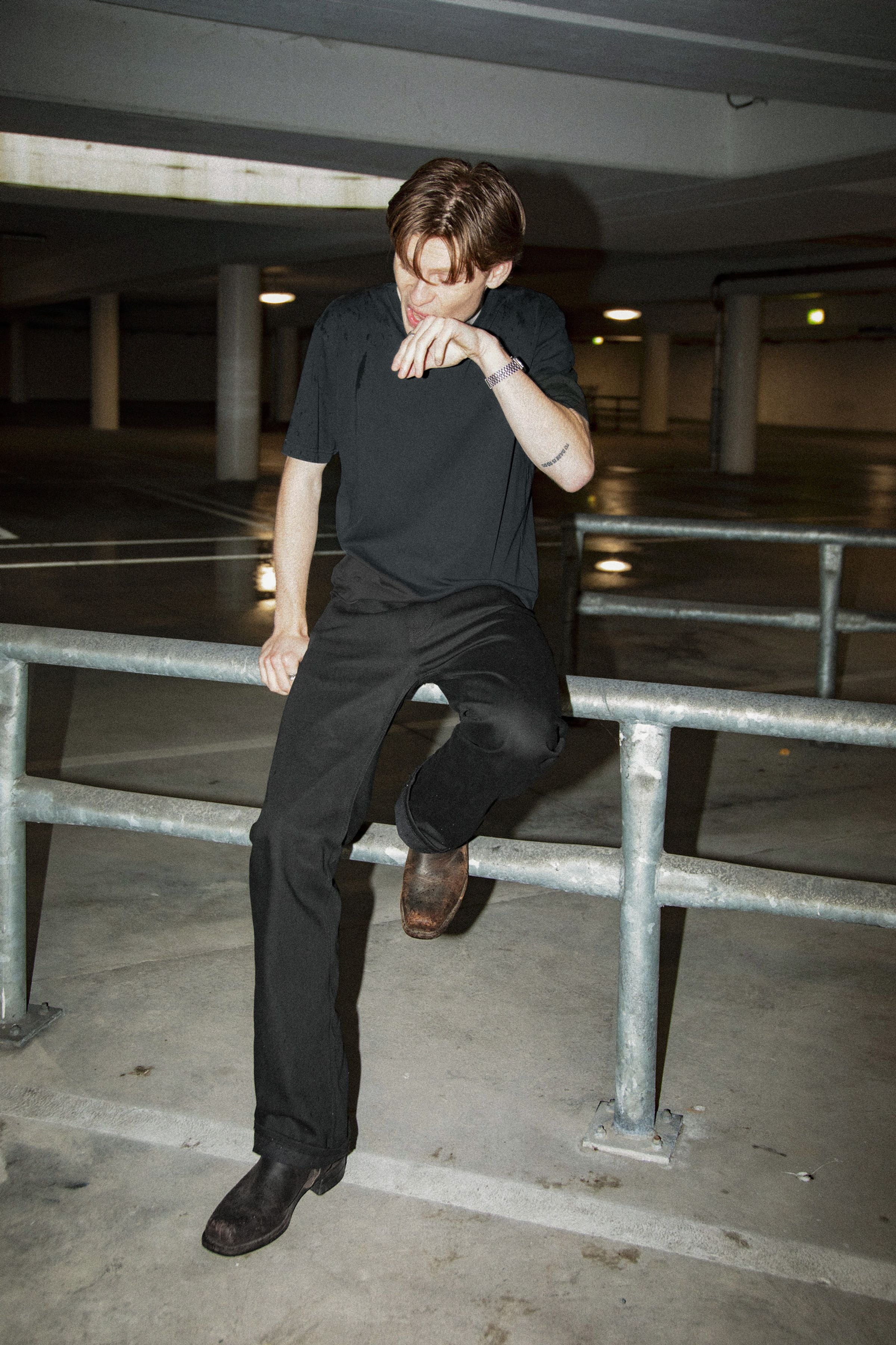 Nudie Jeans Regular Alf Dry Black Selvage, men's regular fit bootcut selvedge jeans in black, shown in a lifestyle setting.